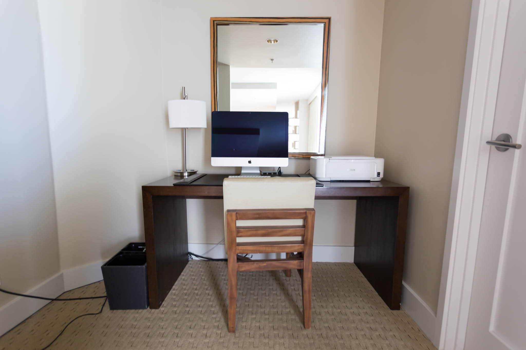 a desk with a computer and a mirror