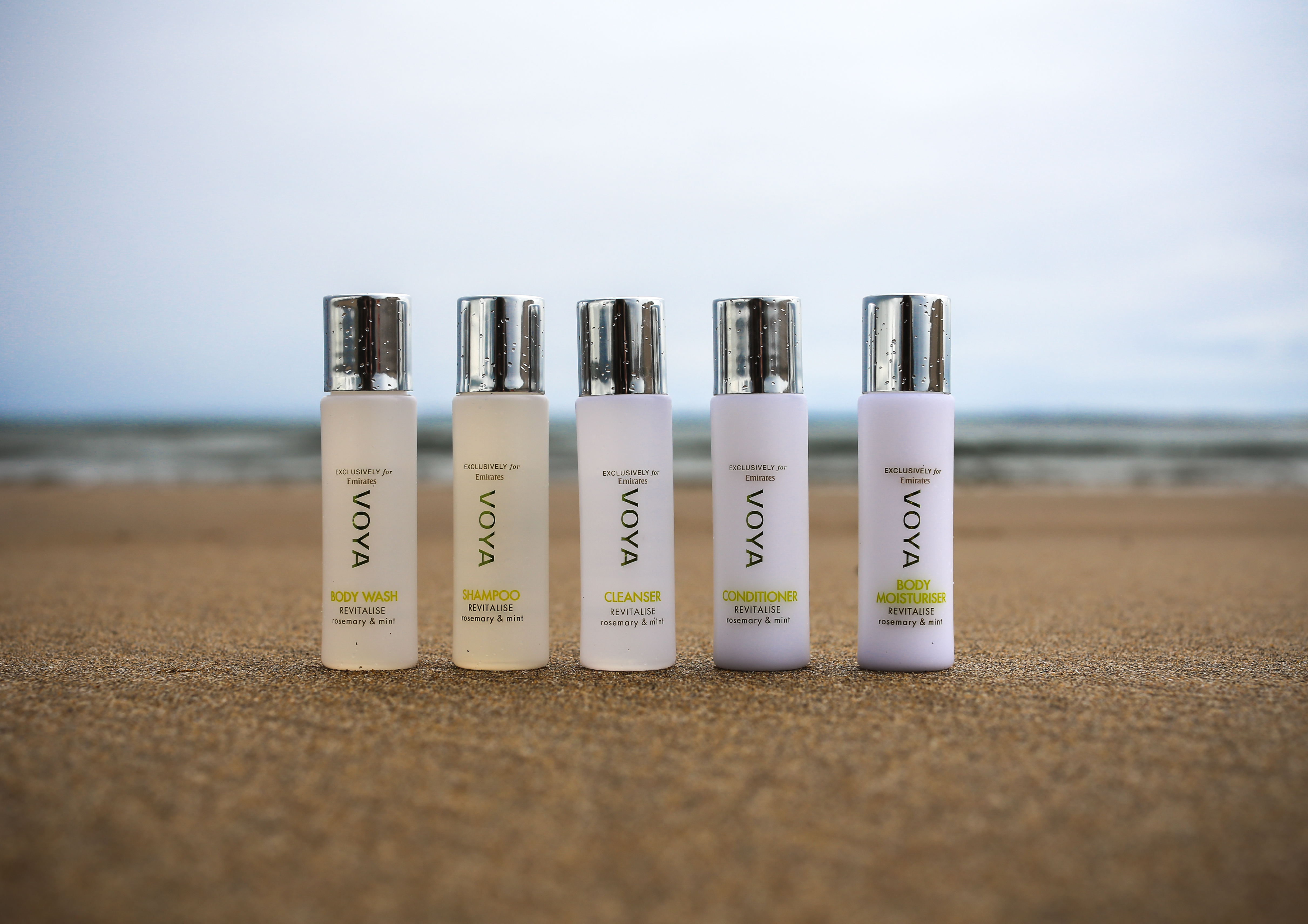 a group of small bottles on sand
