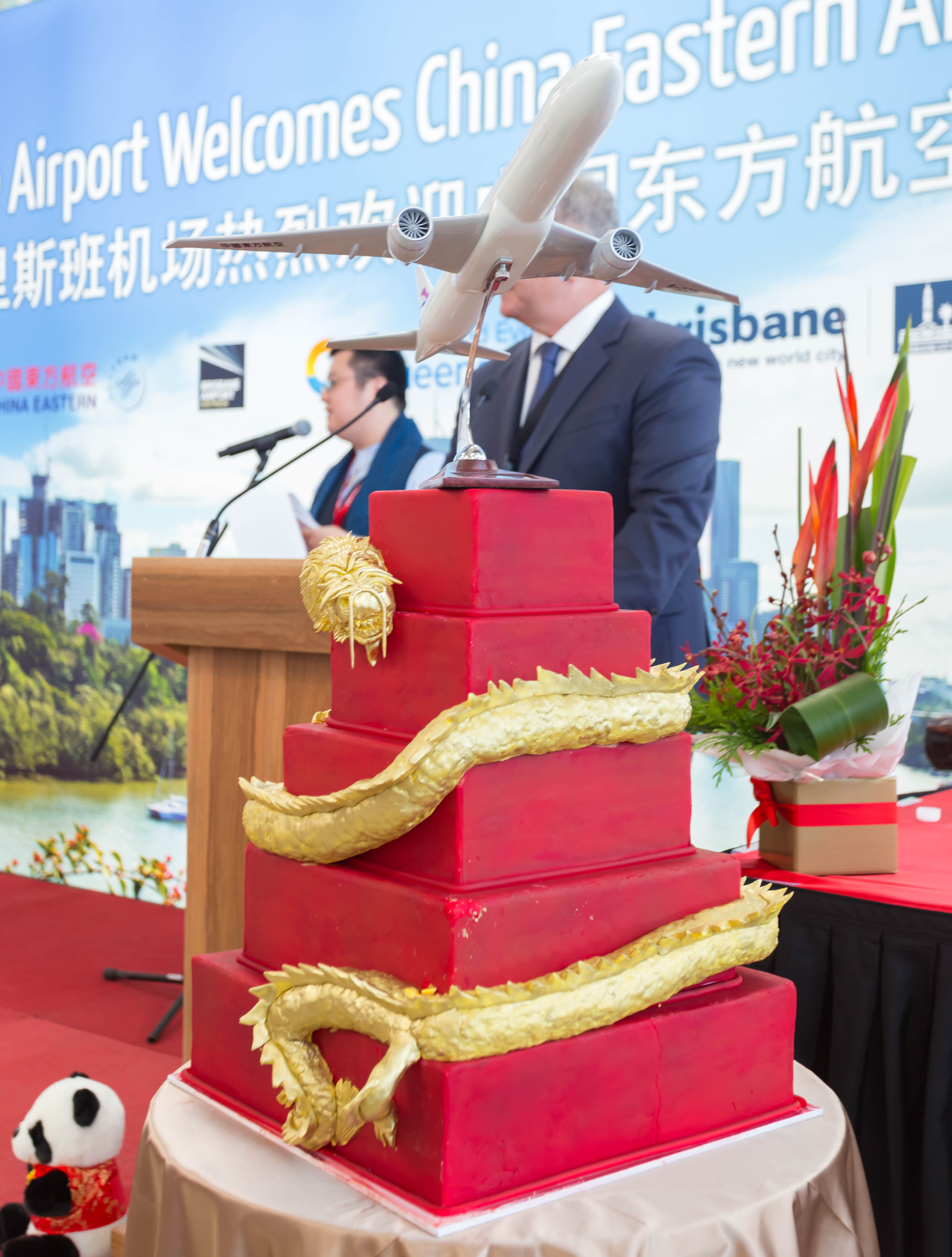 a red cake with a model of an airplane on top