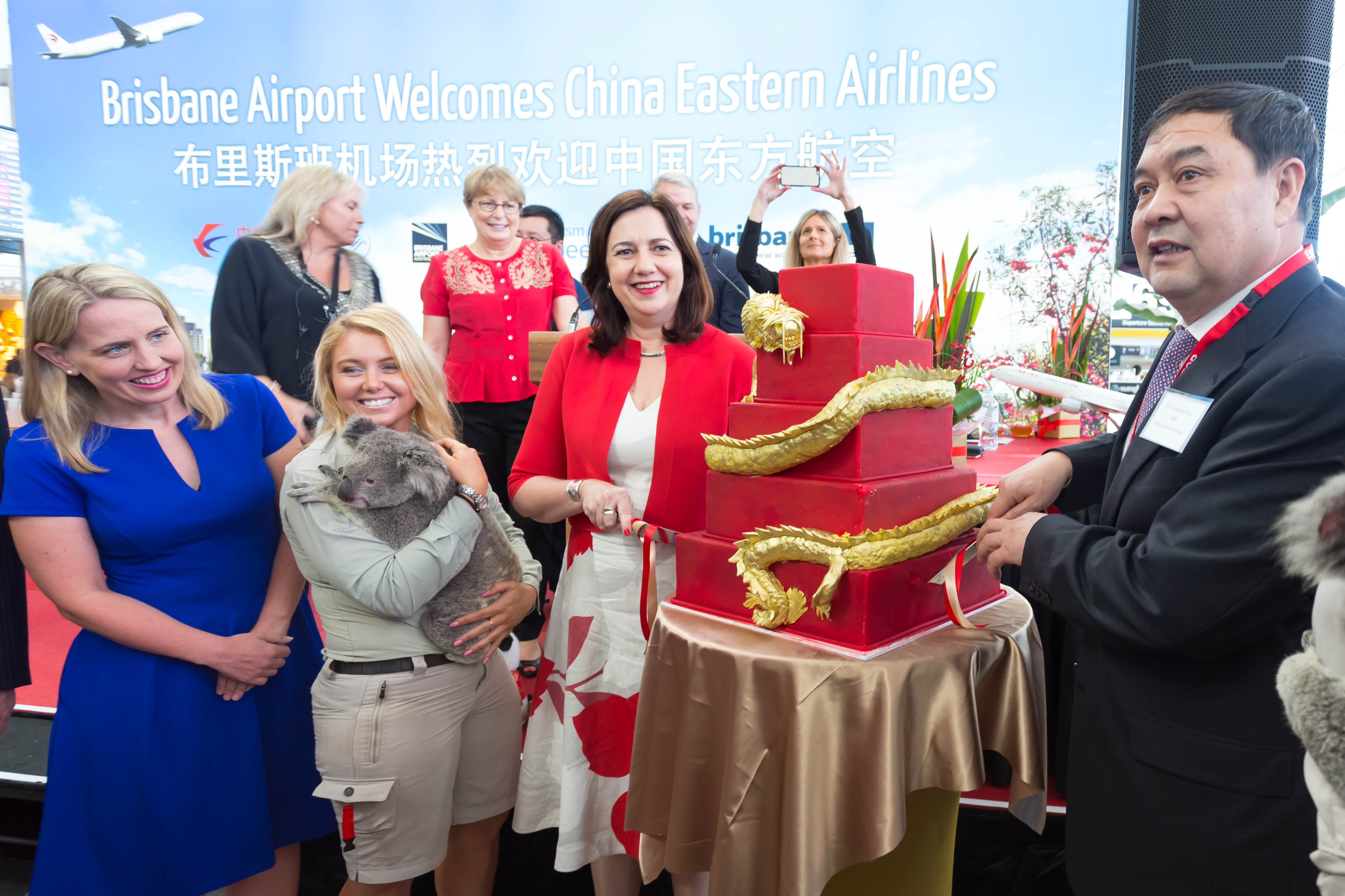 a group of people standing next to a large cake
