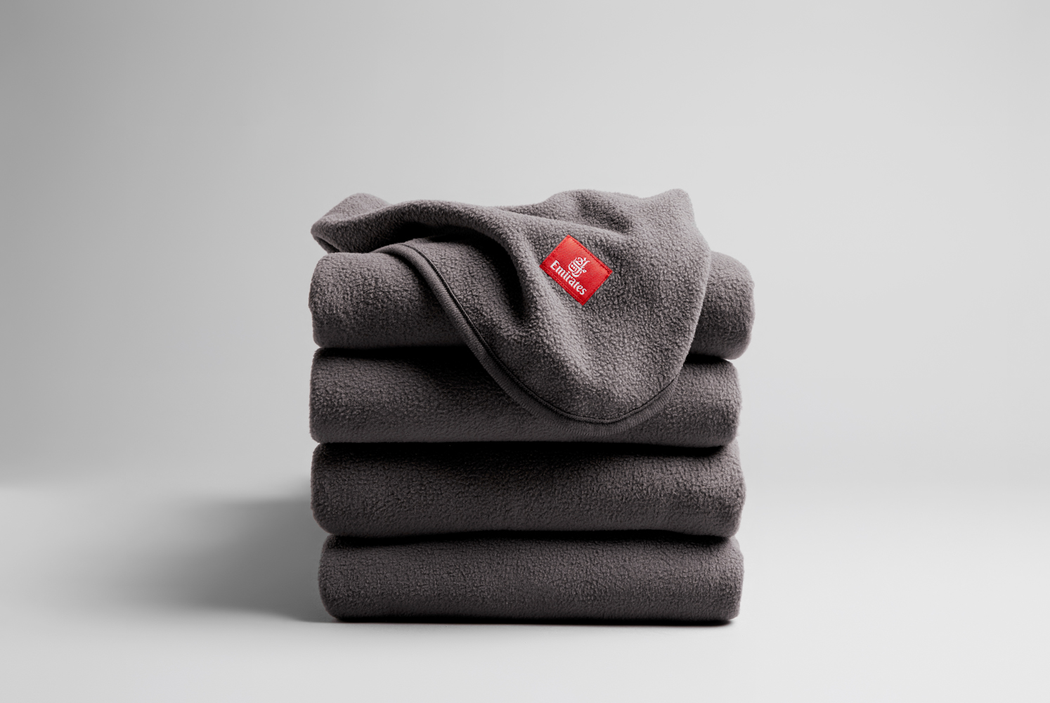 a stack of blankets with a red logo