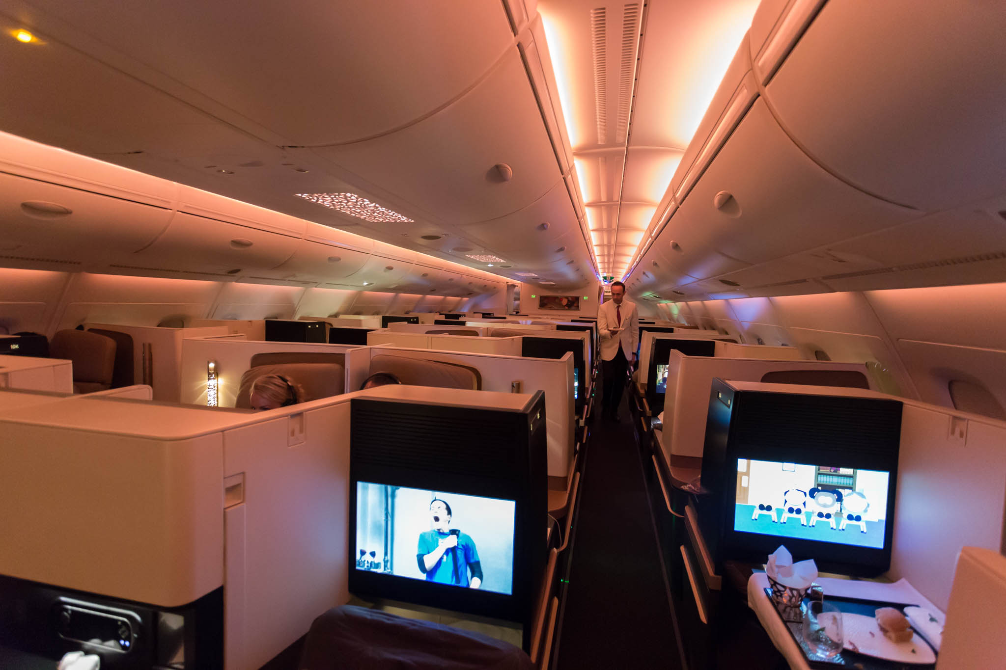 a man standing in an airplane with tvs