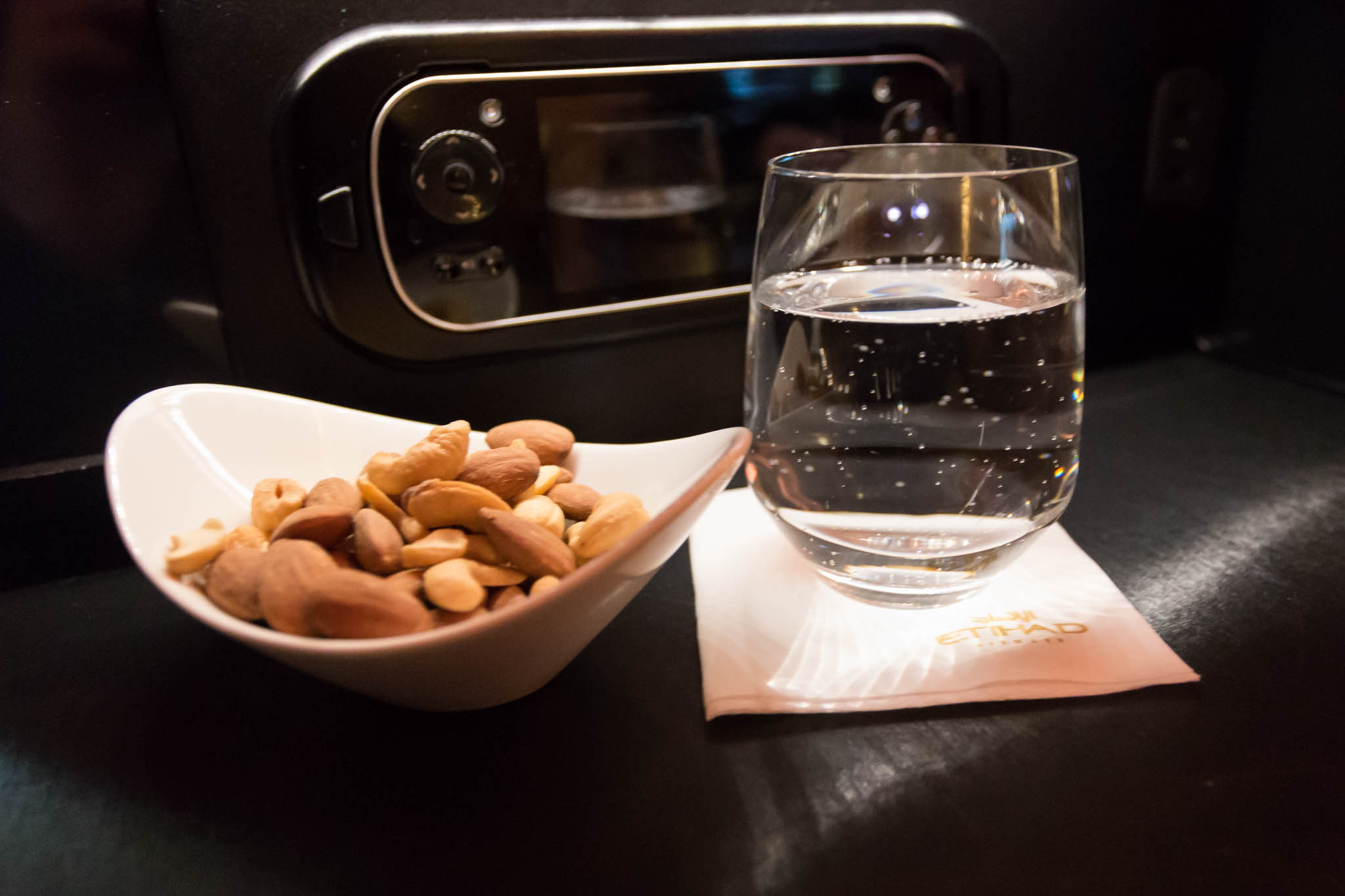 a bowl of nuts and a glass of water