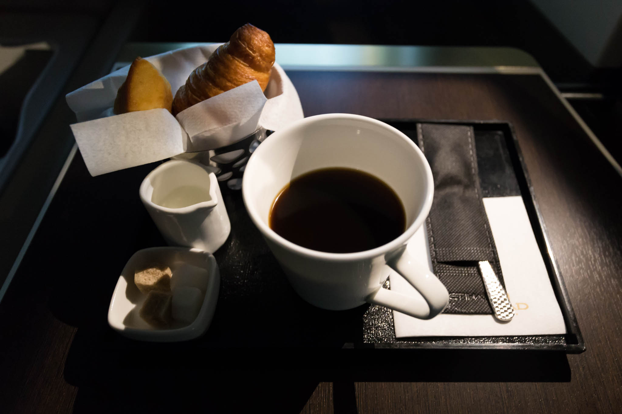 a cup of coffee and croissants on a tray