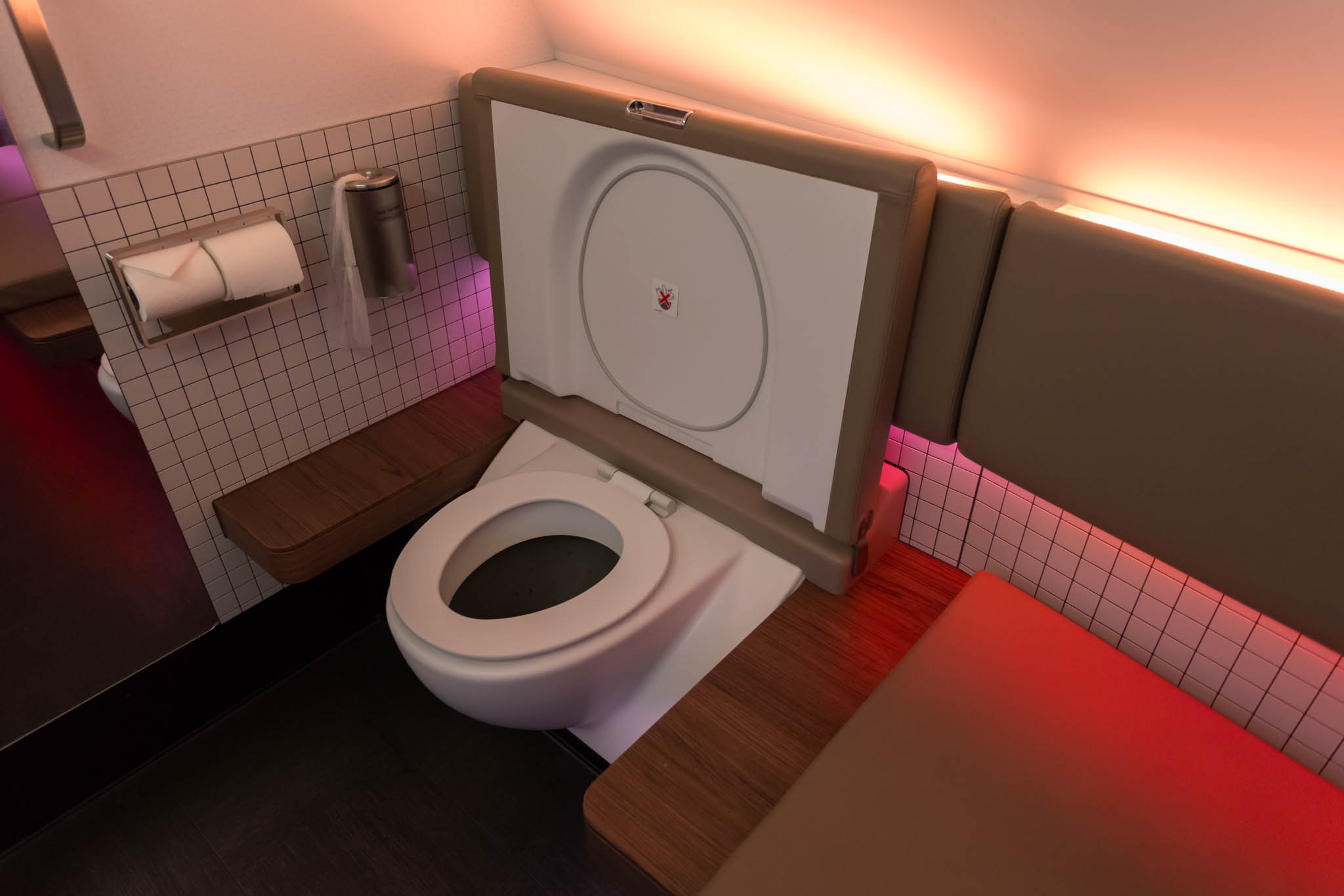 a toilet with a seat and a seat on the wall