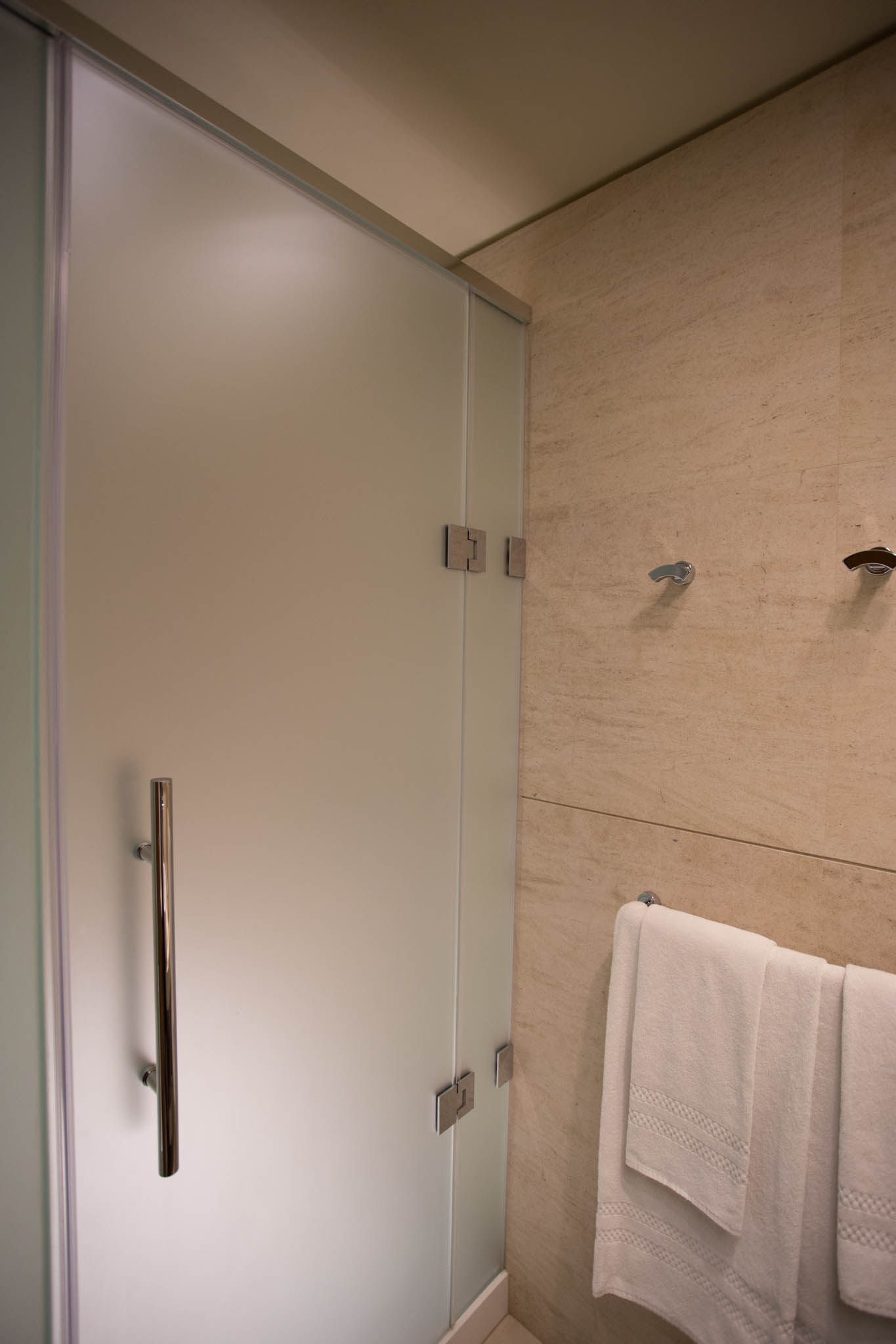 a shower with a white towel on a rack