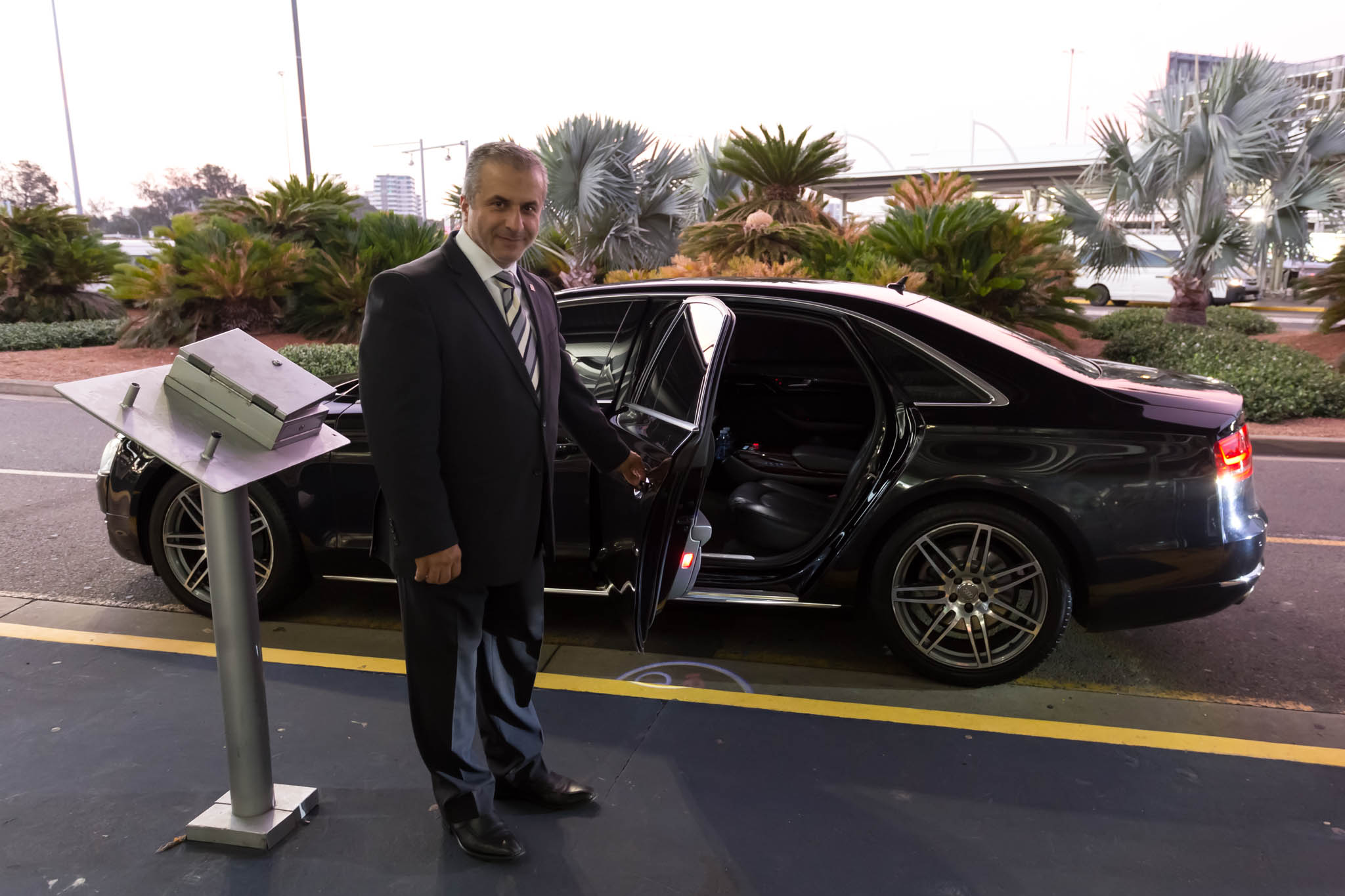 a man in a suit opening the door of a car