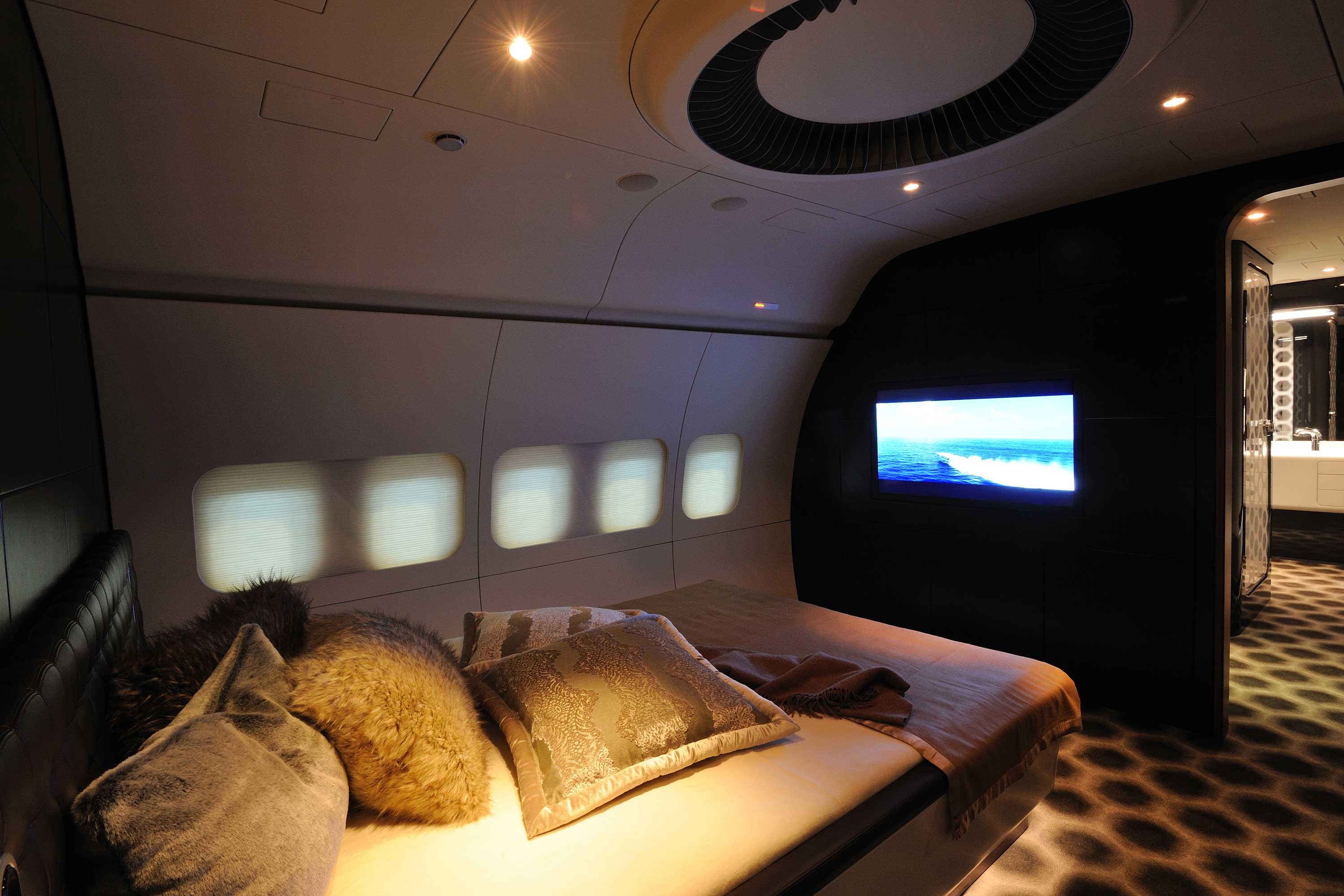 a bed with pillows and a television in the back of it