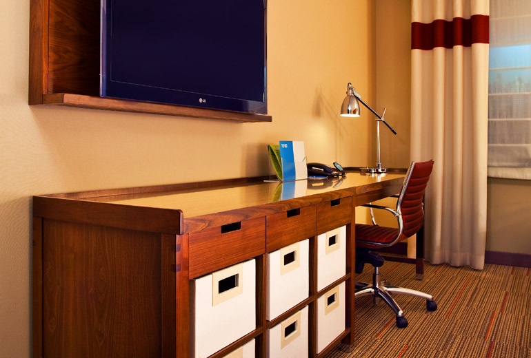 a desk with drawers and a tv on the wall