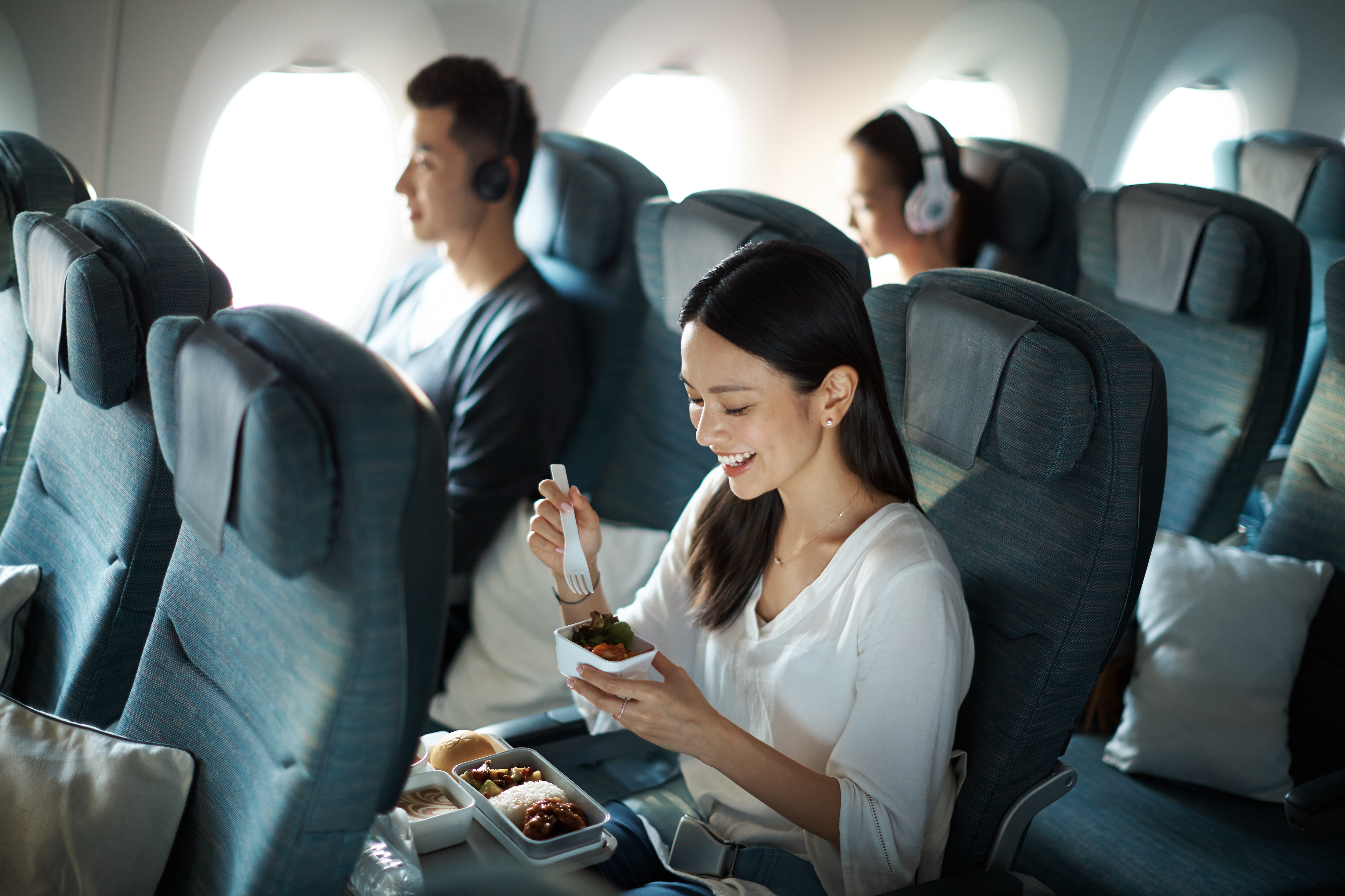 a woman eating food on an airplane