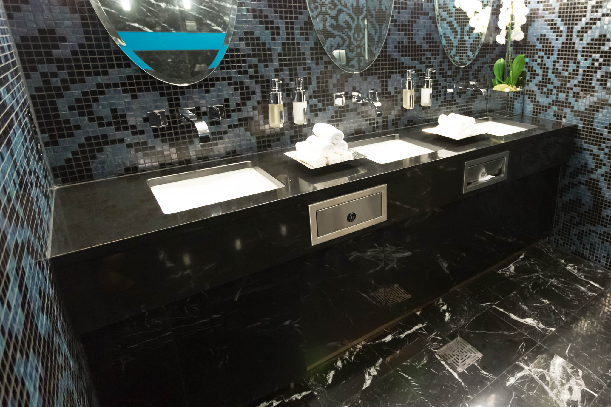 a bathroom with black tile floor and black countertop