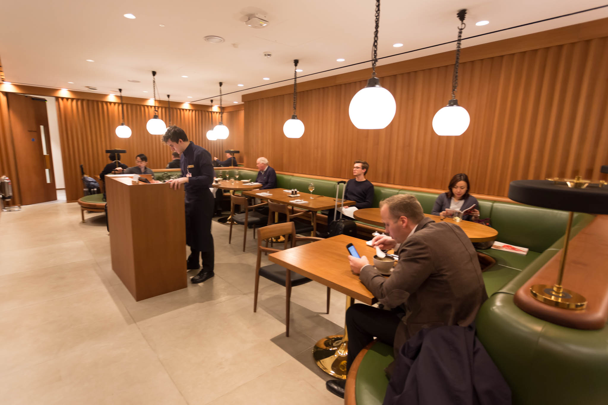 a group of people sitting at tables in a restaurant