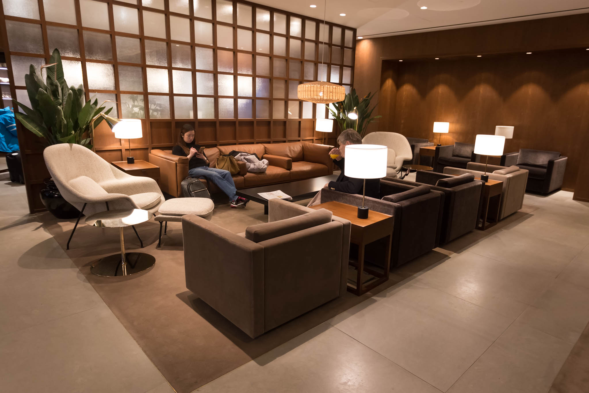 a group of people sitting on a couch in a room with a wood paneled wall