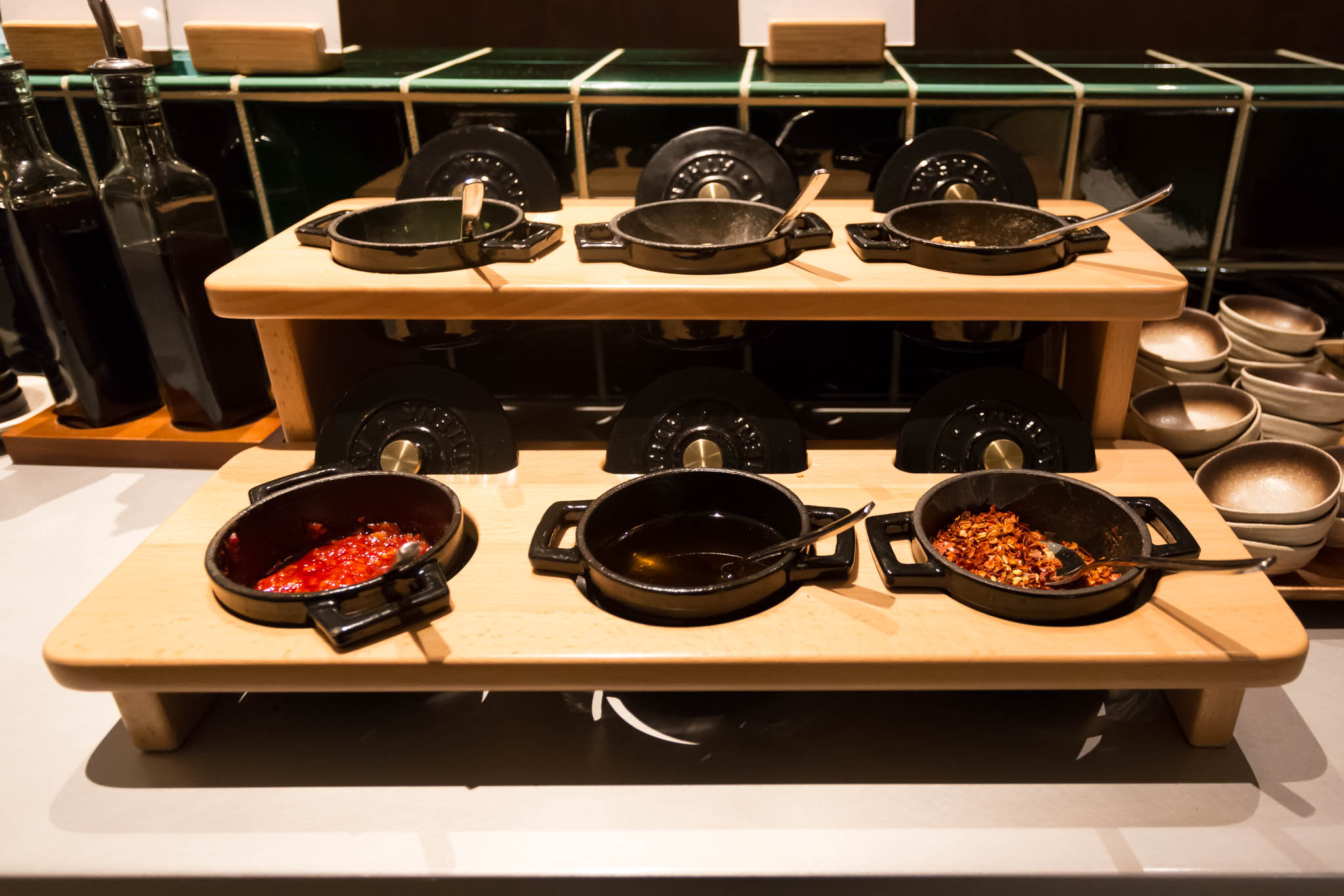 a wooden shelf with pans and sauces