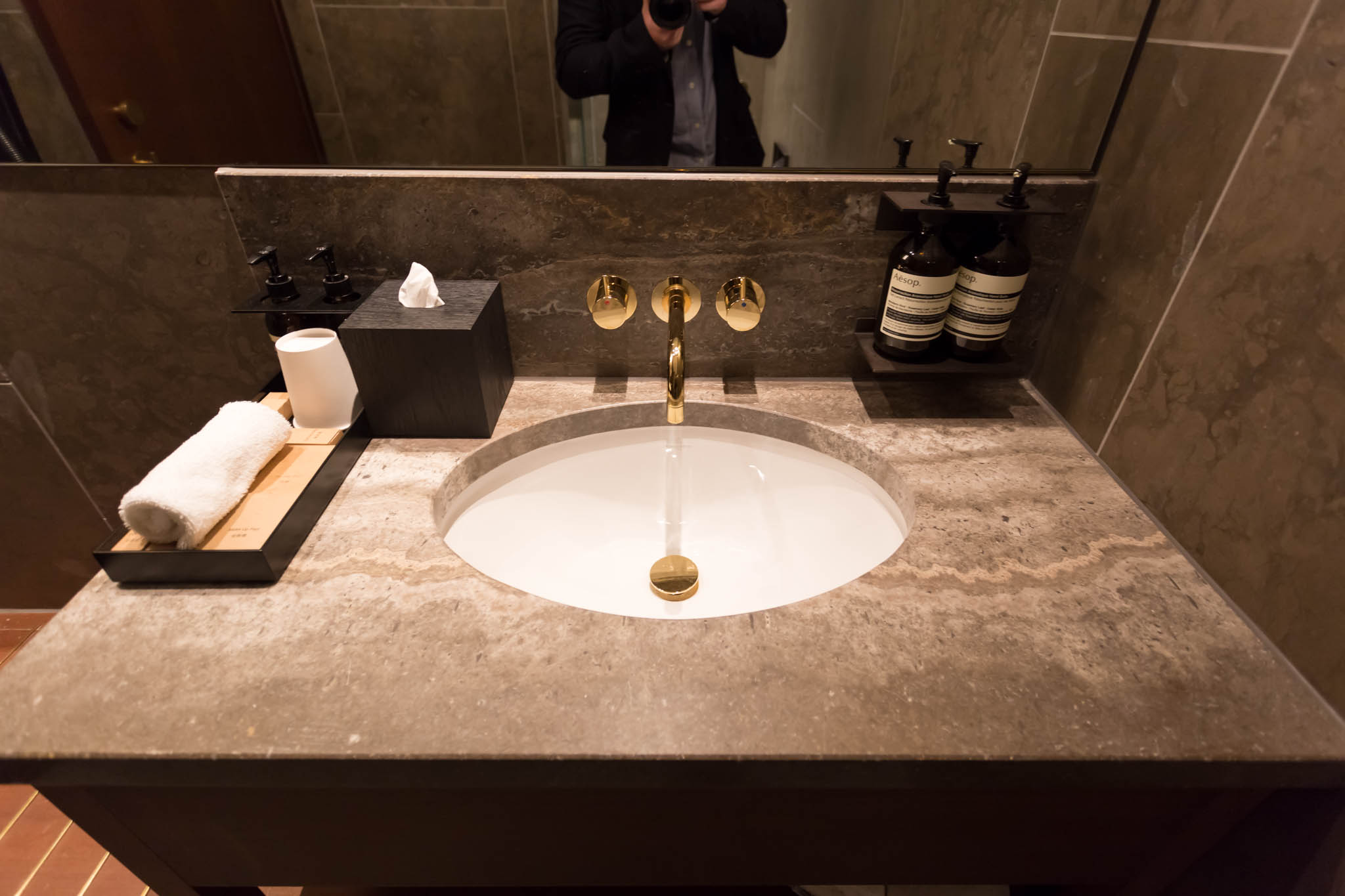 a sink with a mirror and bottles