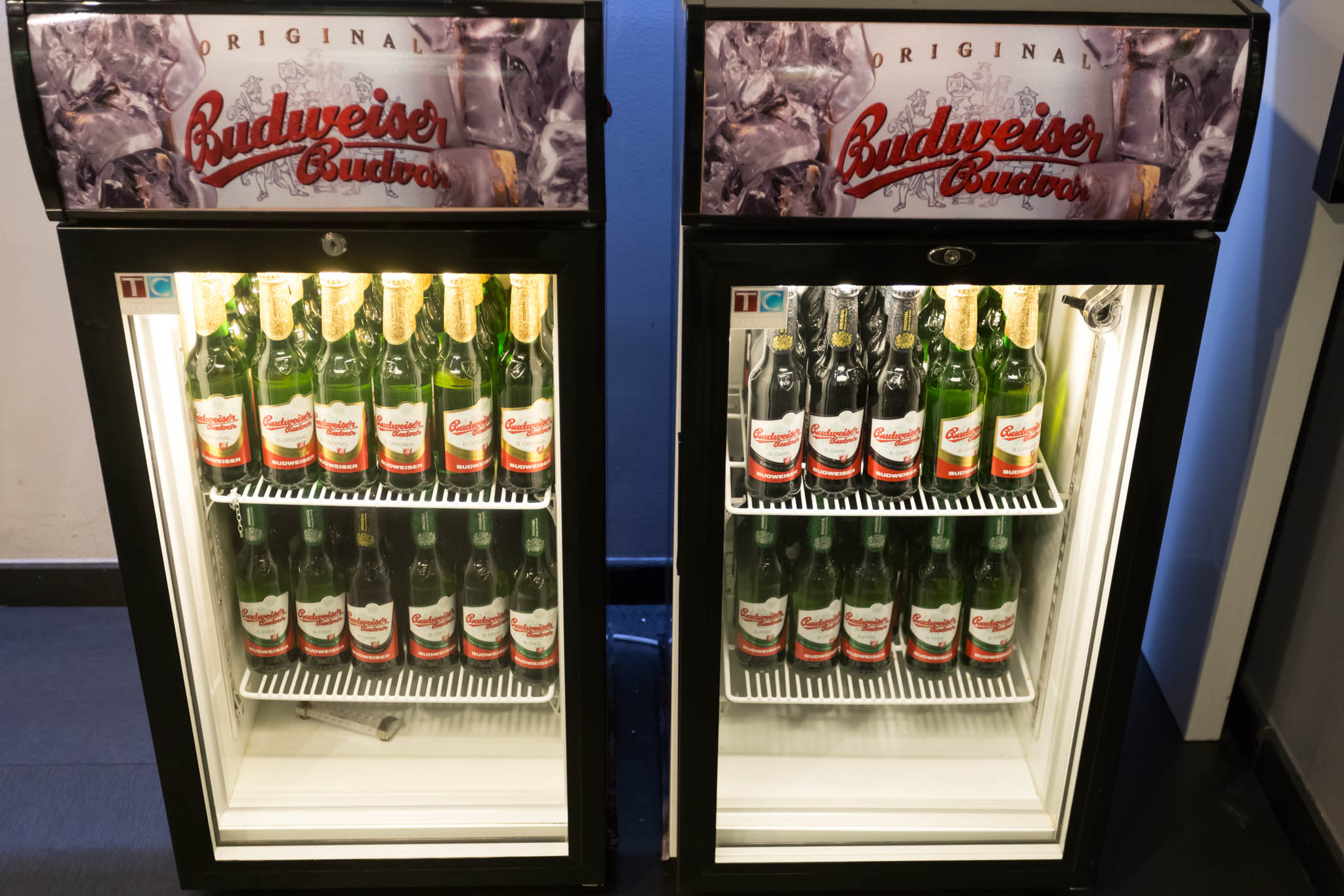 two refrigerators with bottles of beer