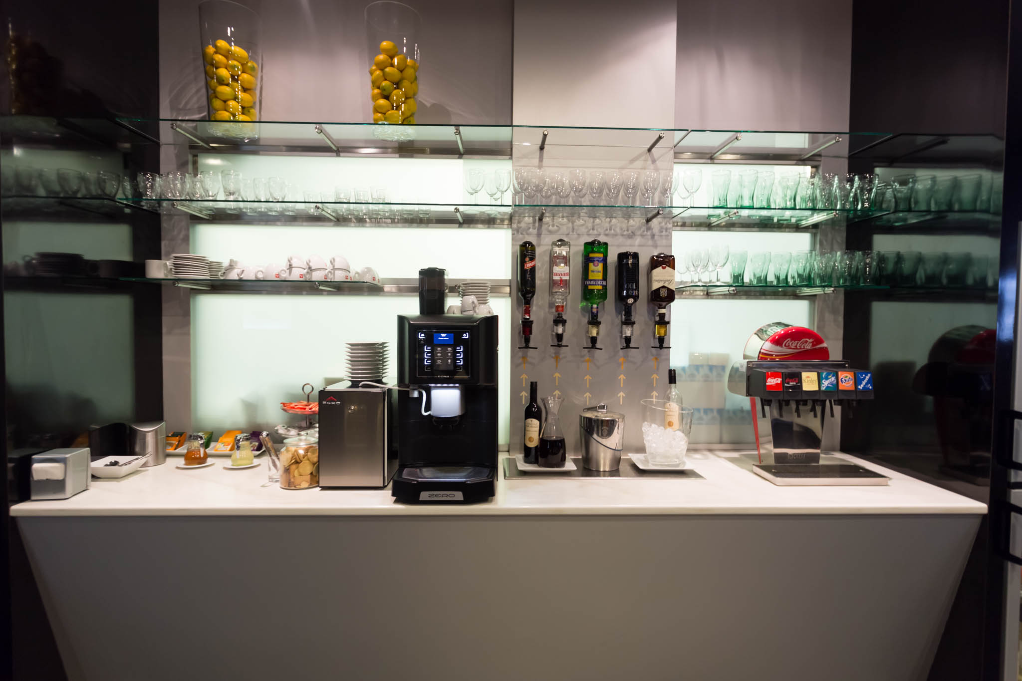 a counter with a coffee machine and drinks dispensers
