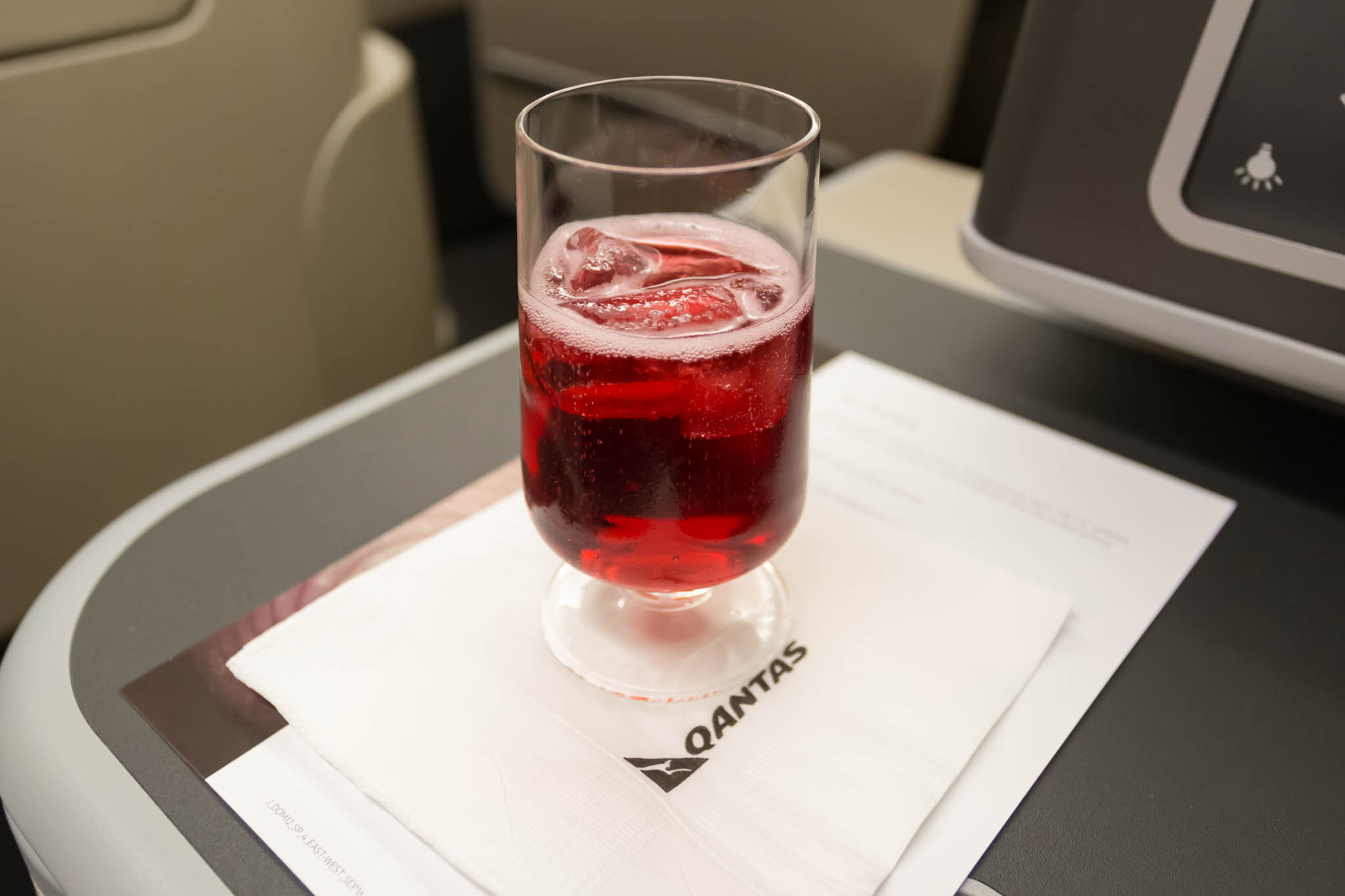a glass of red liquid on a napkin