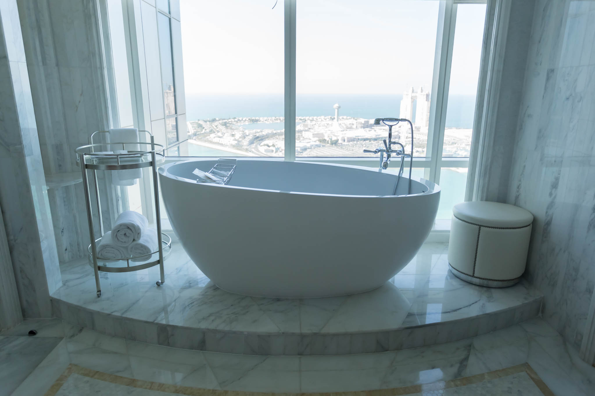 a large white bathtub with a view of the ocean