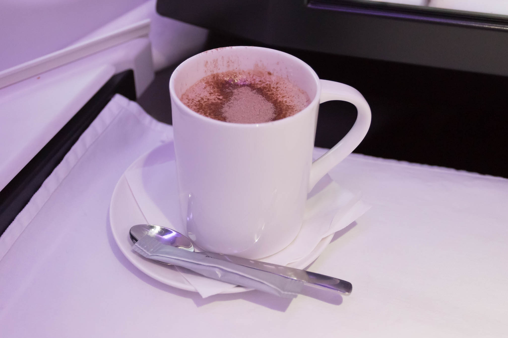 a cup of hot chocolate on a saucer with a spoon