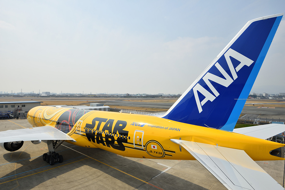 a yellow airplane with a star wars painted tail