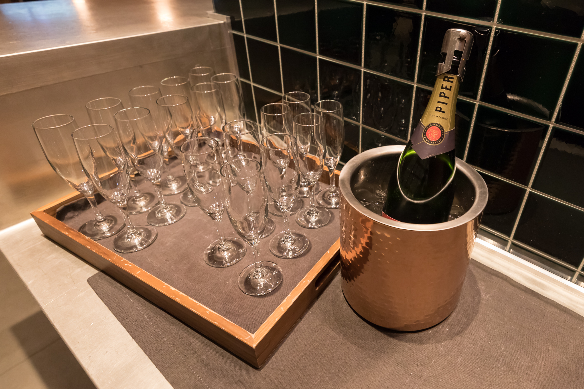 a bottle of champagne in a bucket with many empty wine glasses