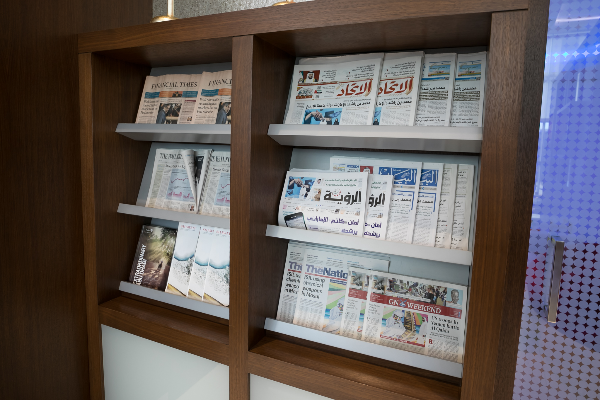 a shelf with several newspapers on it