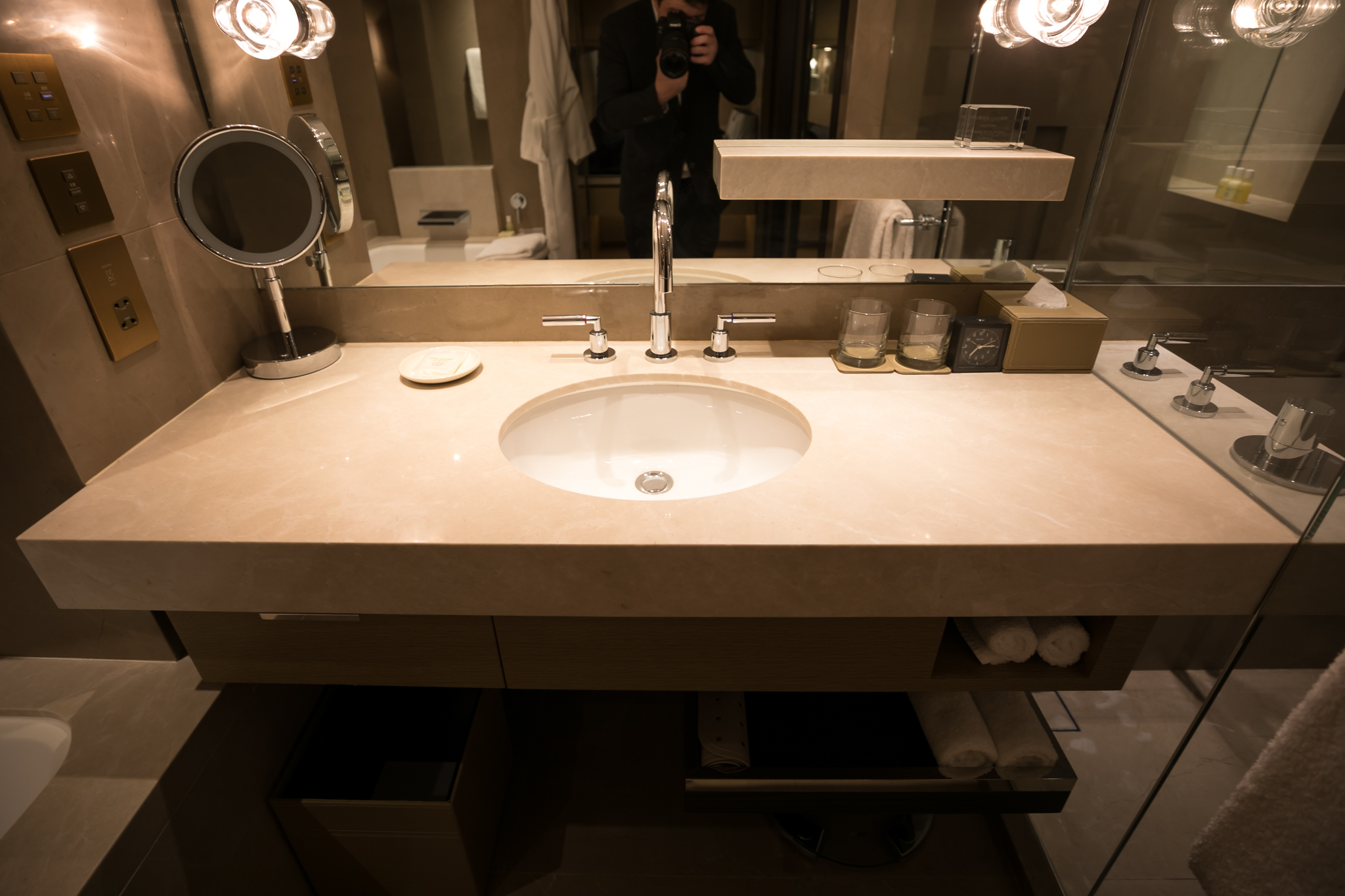 a person taking a picture of a bathroom sink