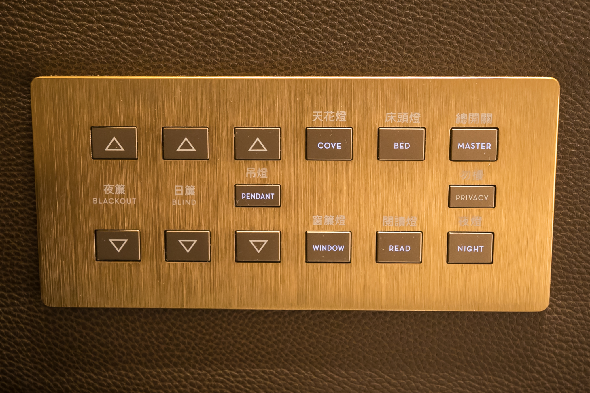 a gold rectangular panel with black buttons