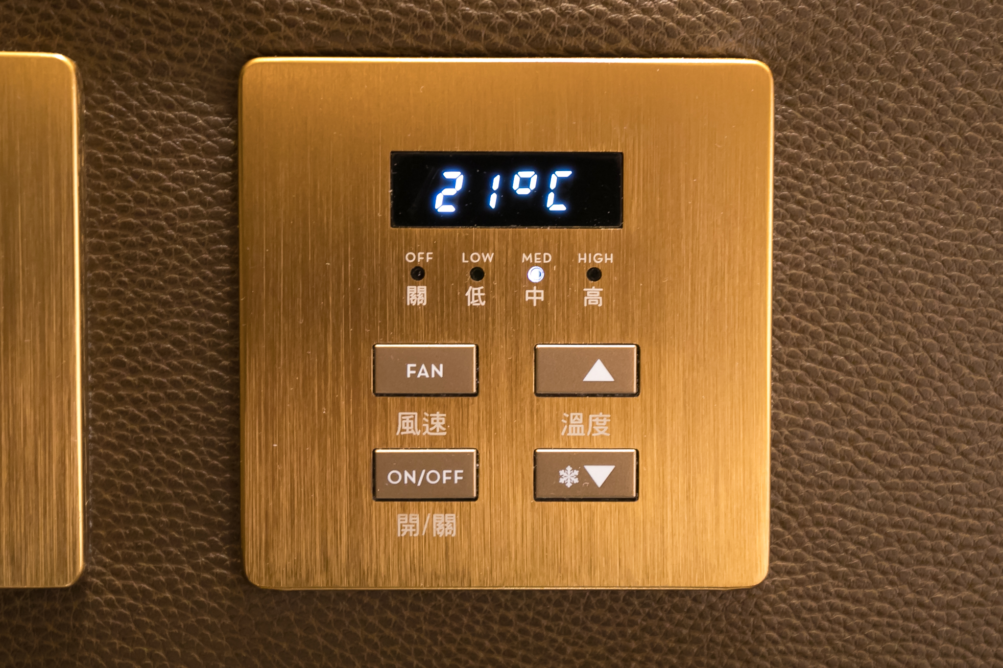 a gold square panel with buttons and a digital display