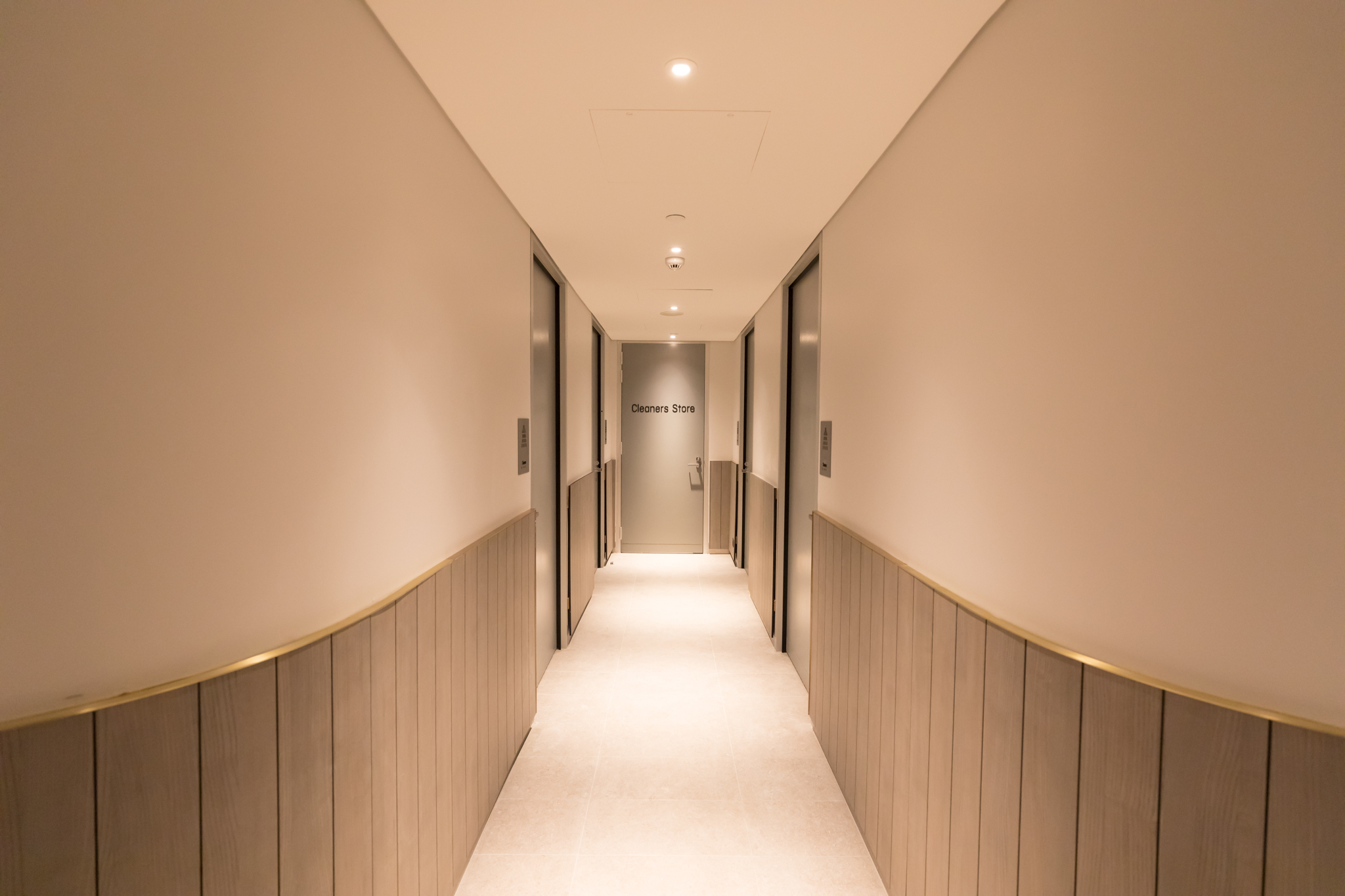 a hallway with doors and a white floor