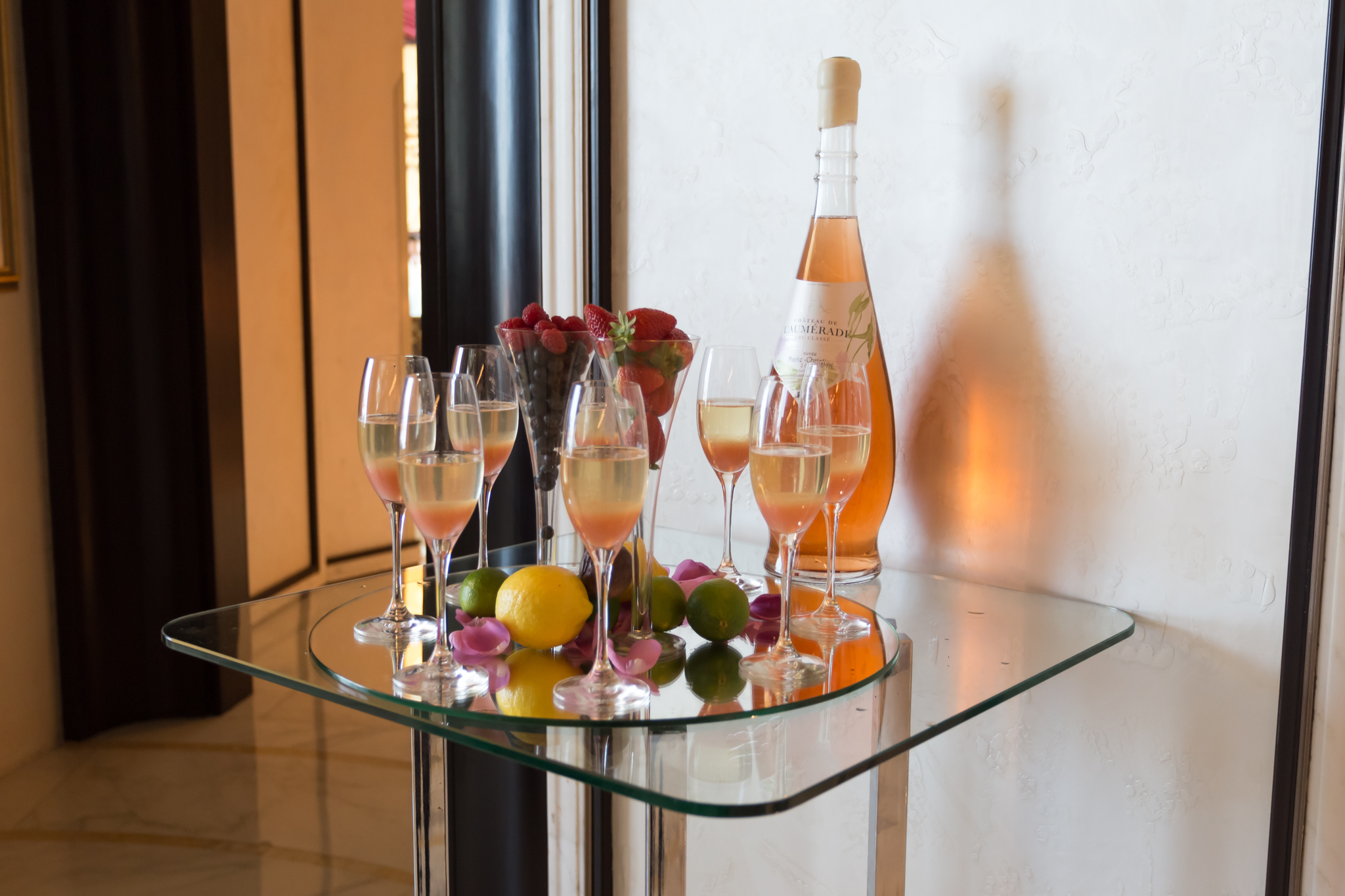 a group of glasses of wine and fruit on a table