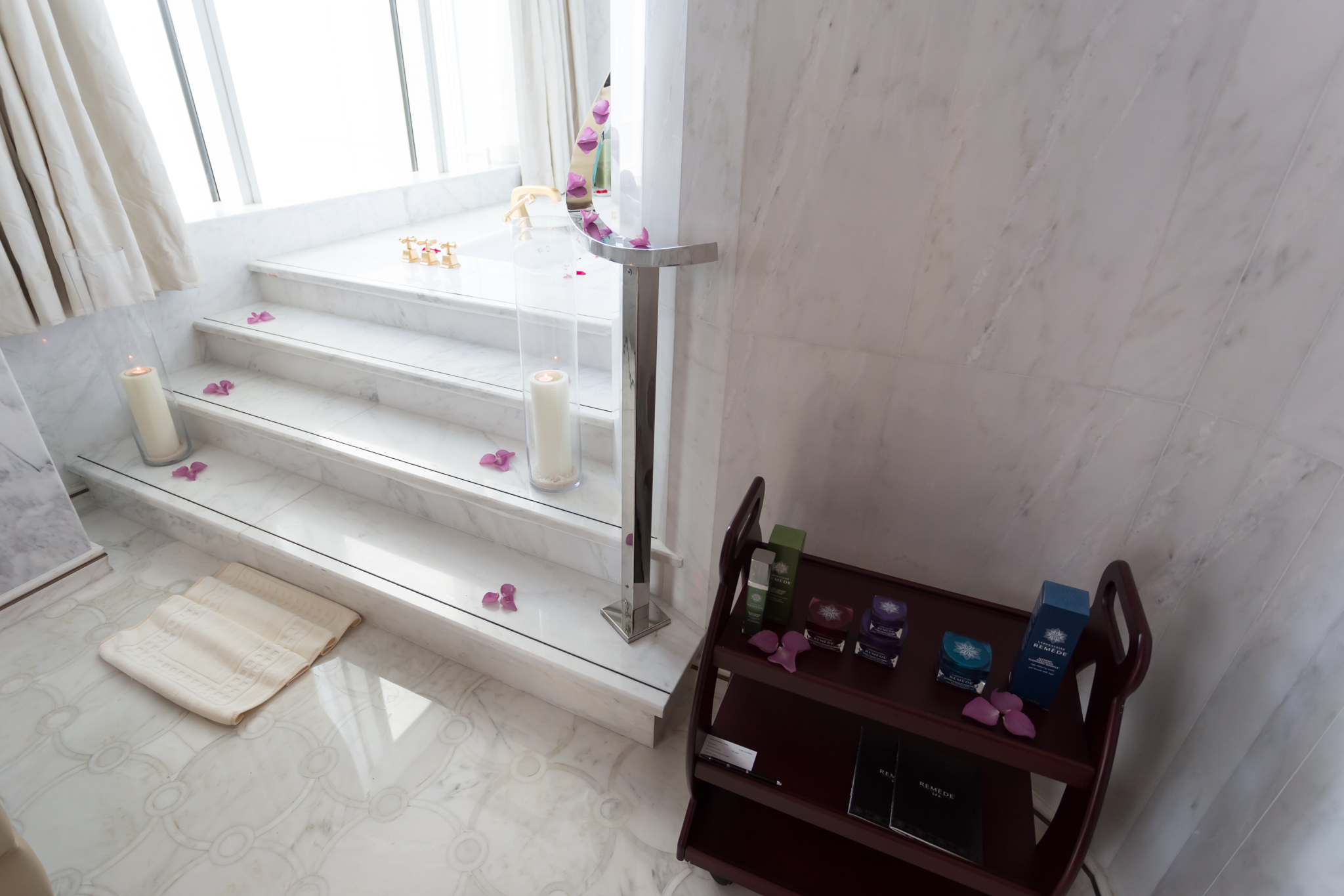 a white marble staircase with a shelf and a candle