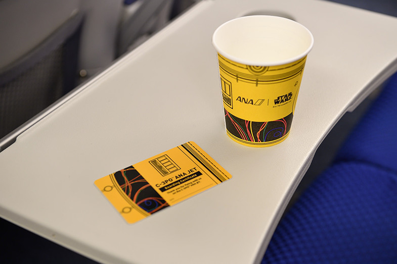 a yellow cup and a card on a table
