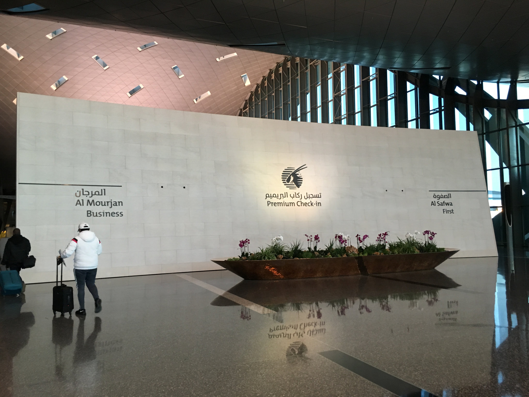 a person walking in a large room with a large planter