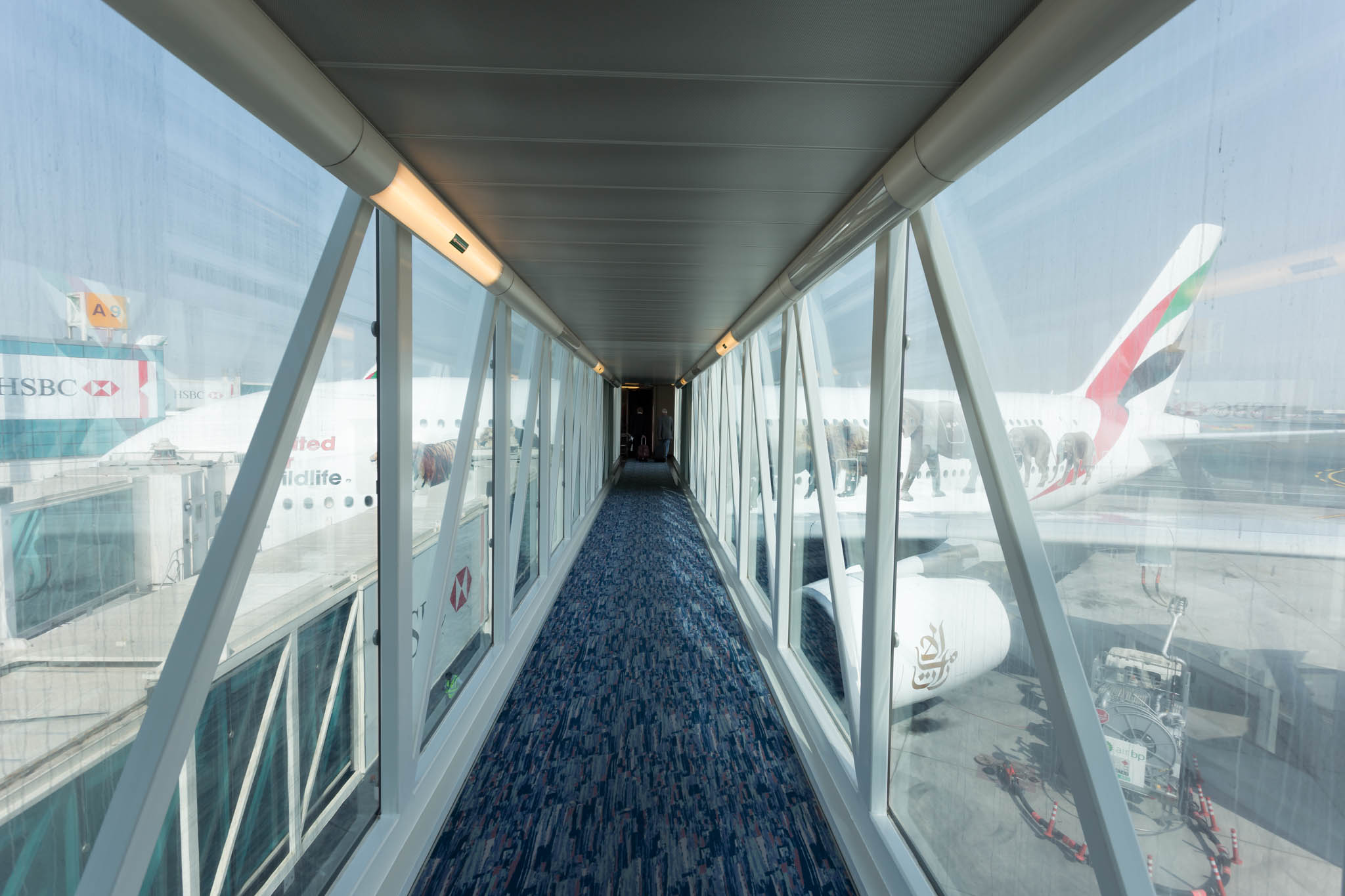 a long hallway with windows and a plane in the background