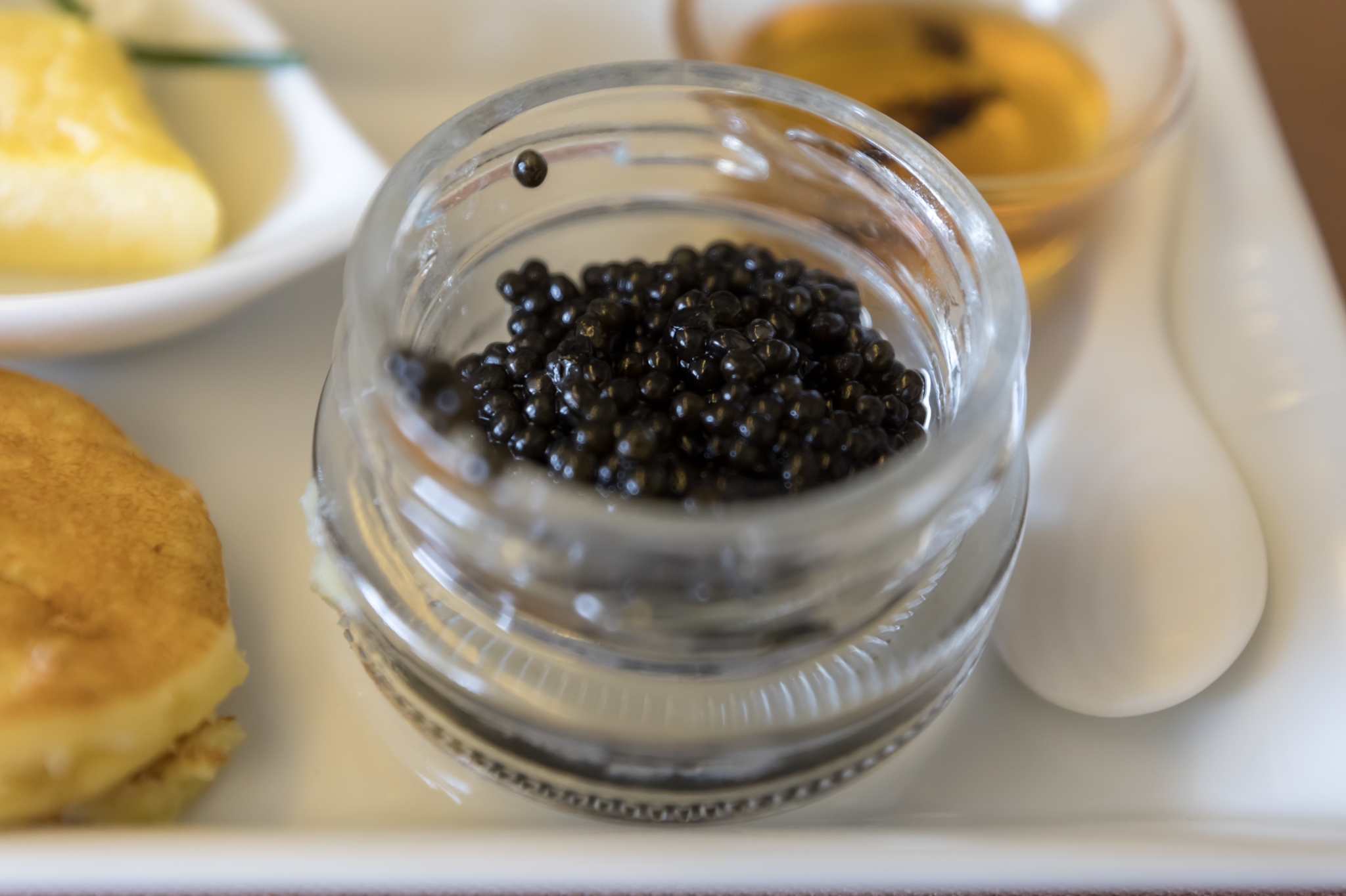 a glass jar with black caviar inside
