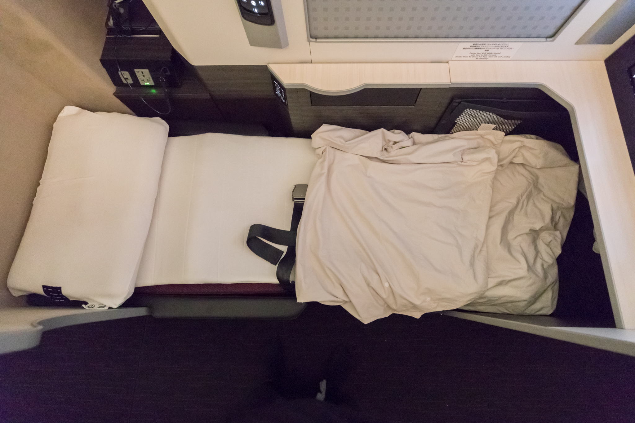 a bed with a white sheet and a black strap