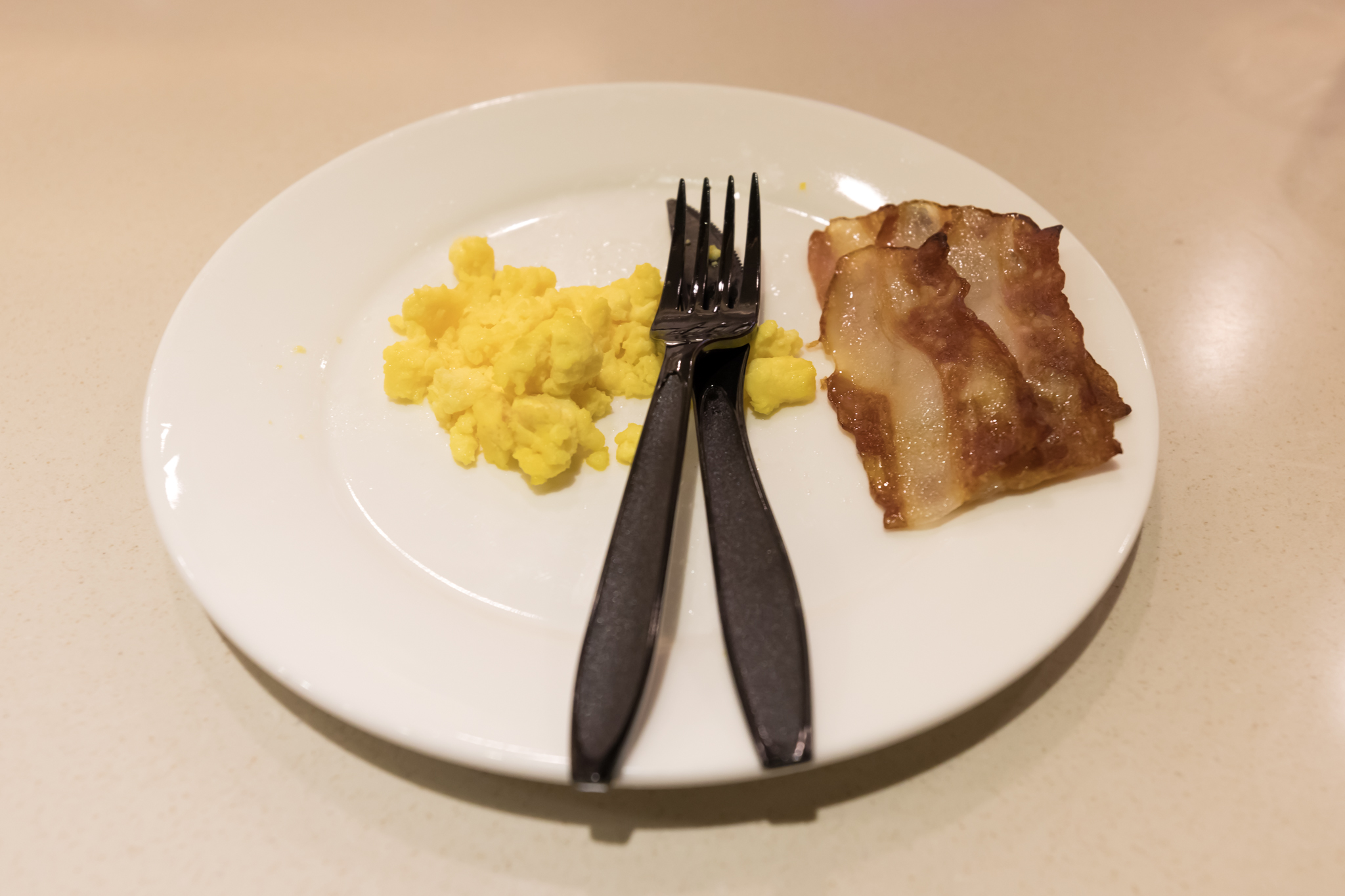 a plate with scrambled eggs and bacon
