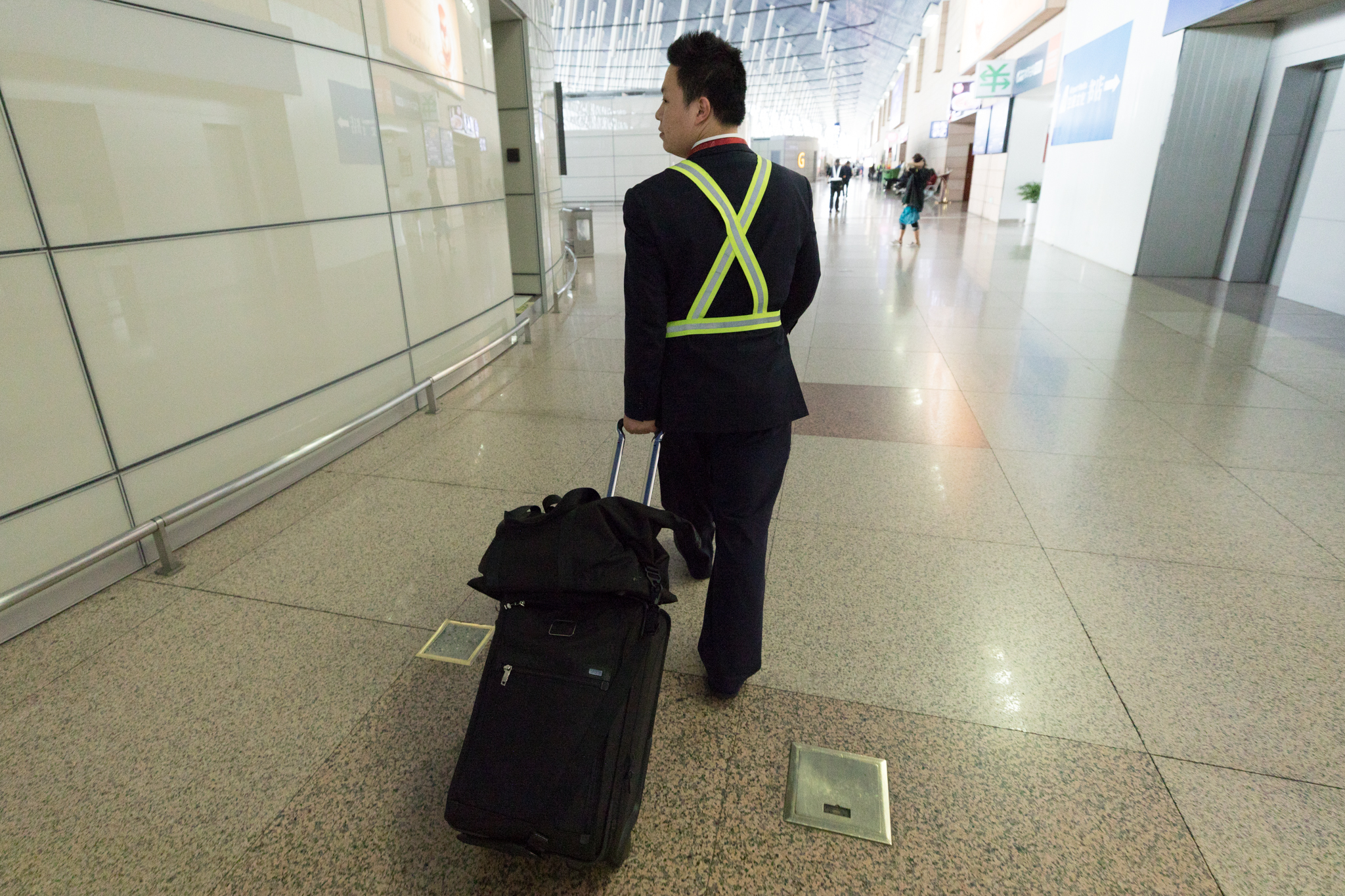 a man in a suit pulling his luggage