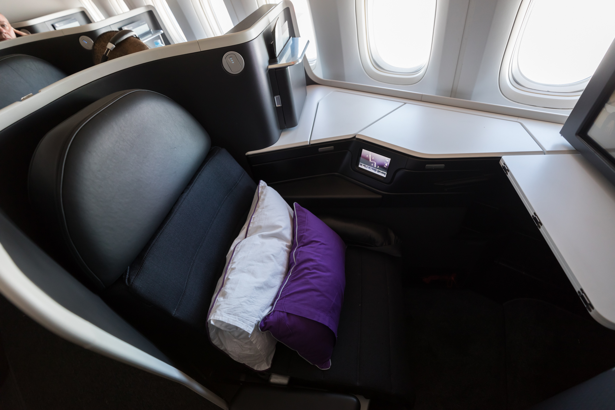 a seat with a pillow and a purple pillow on it