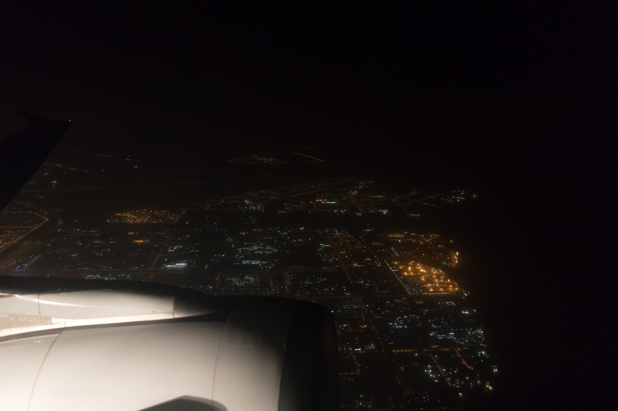 an airplane wing and a city at night
