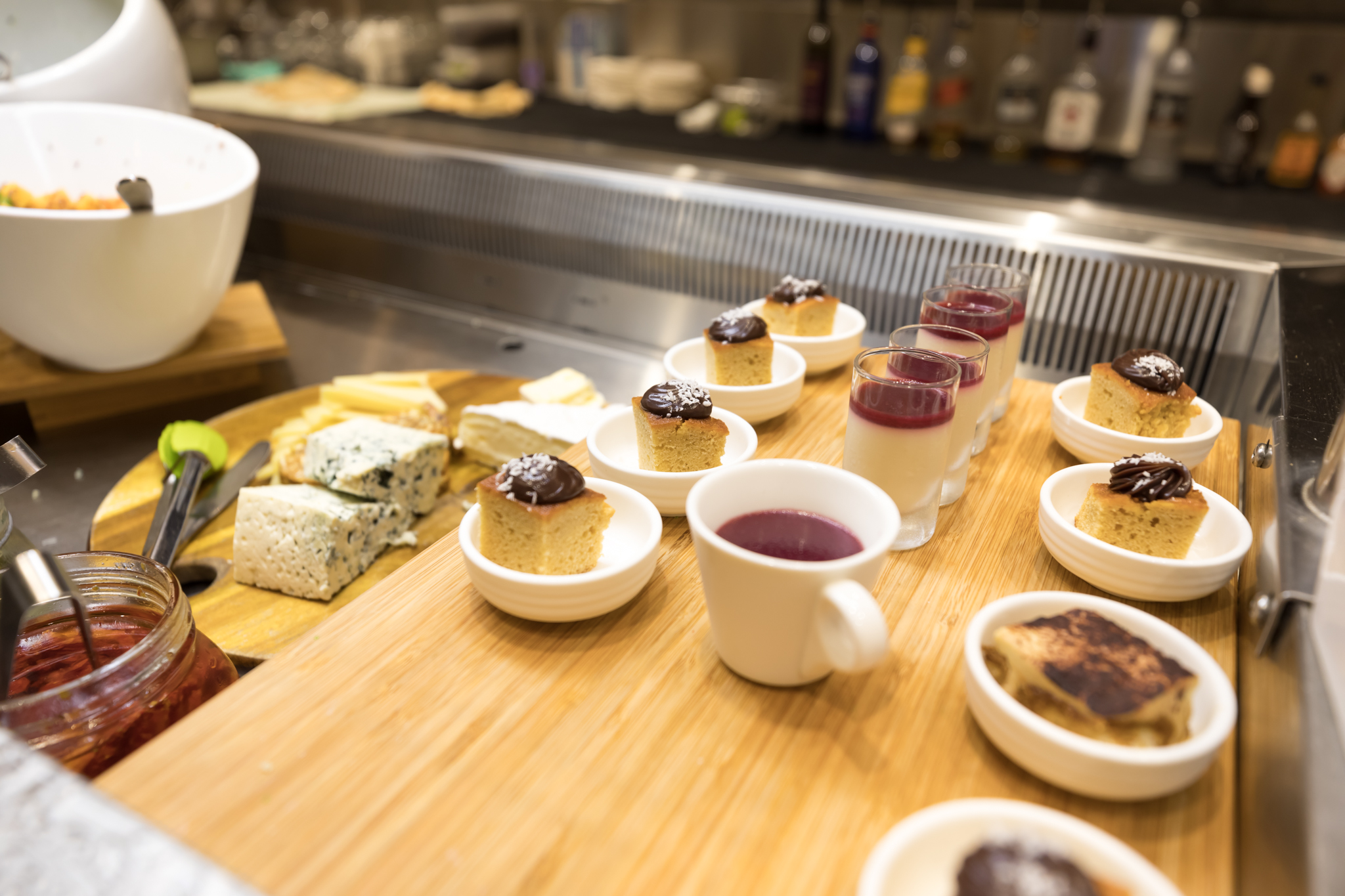 a table with small desserts and cups of liquid