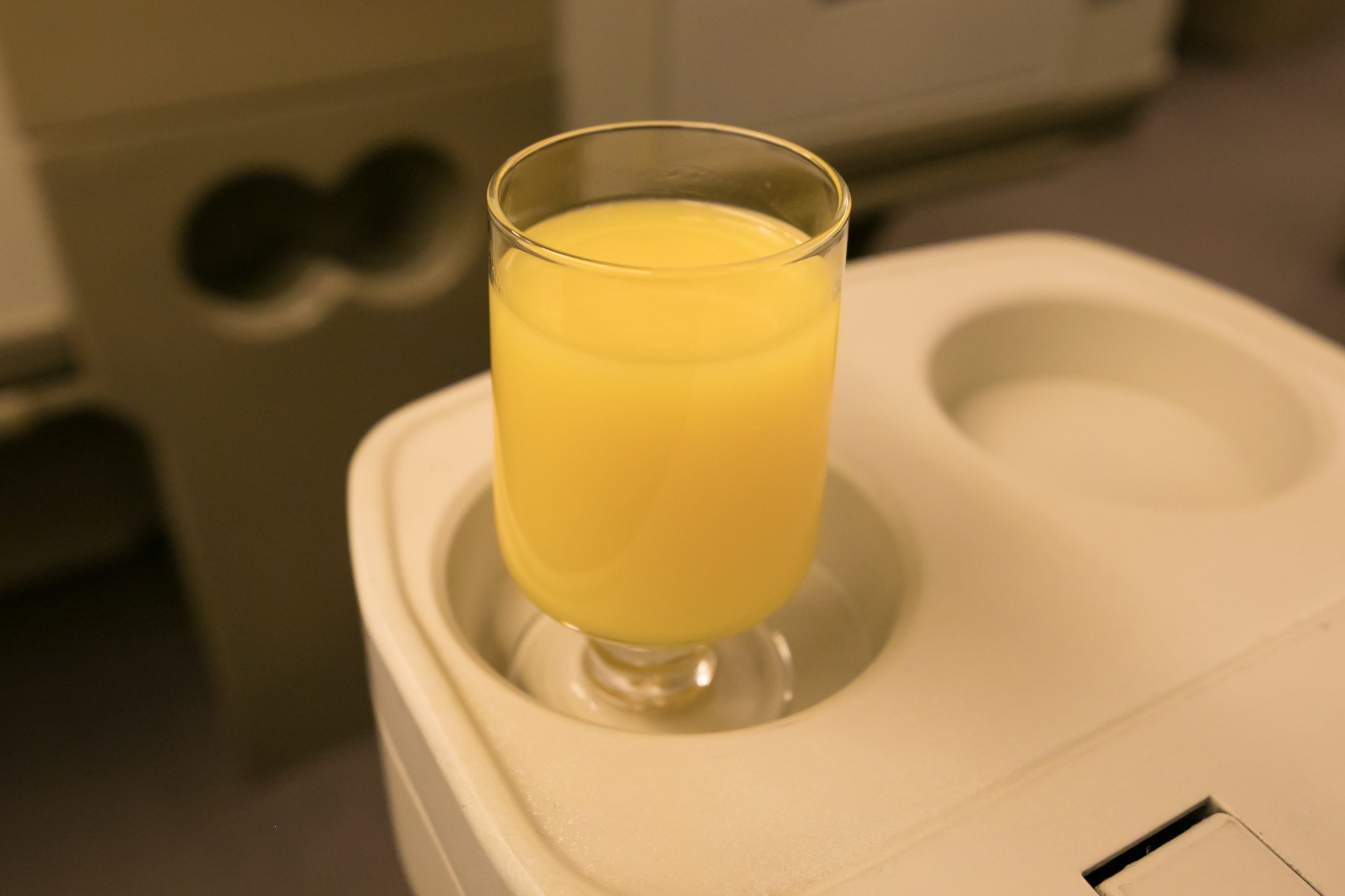 a glass of orange juice on a tray