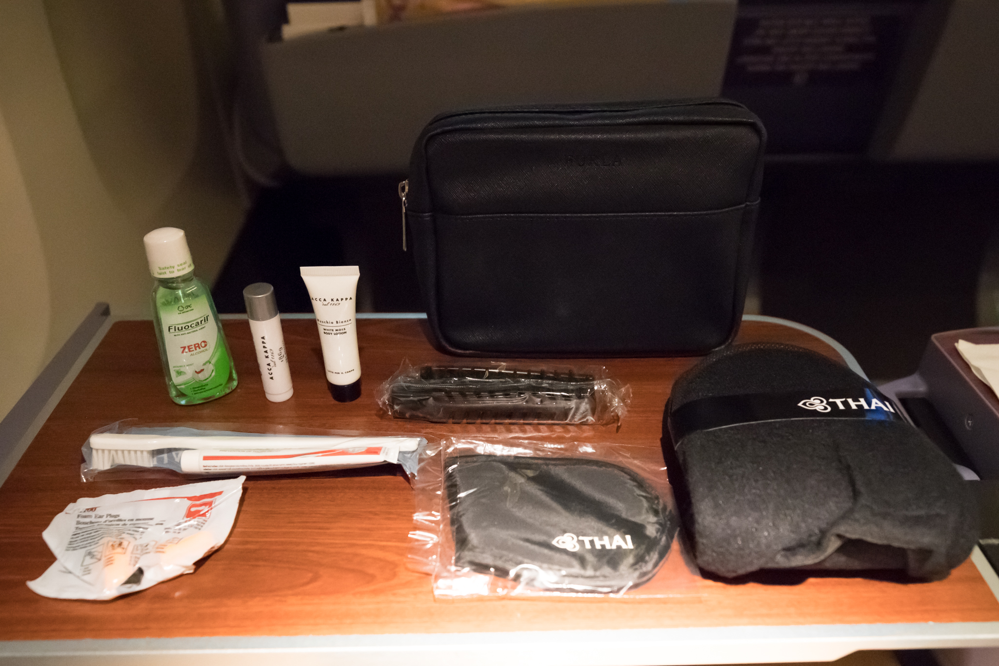 a table with a bag and a small toiletries and a small black bag