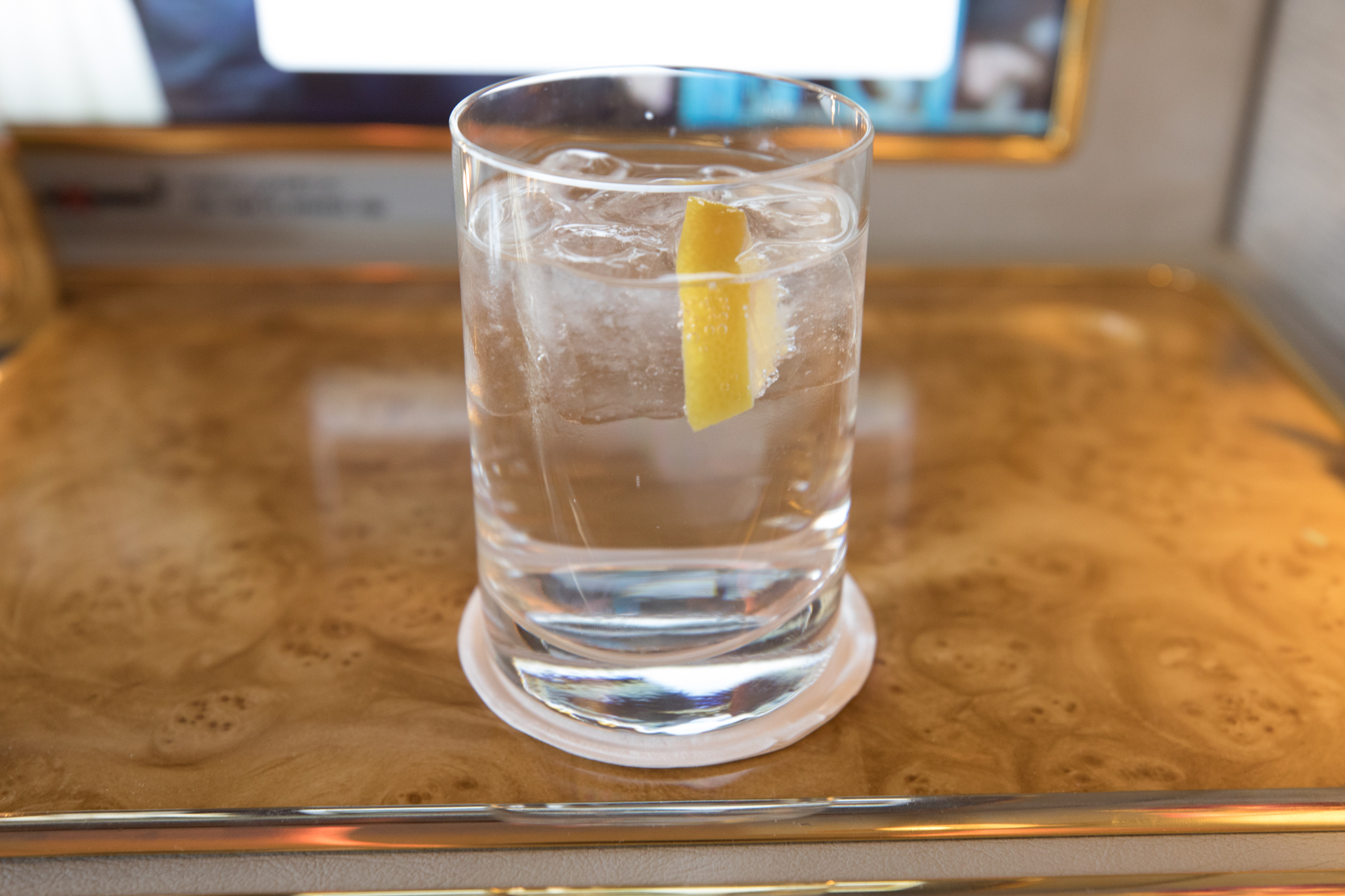 a glass of water with ice and a lemon wedge