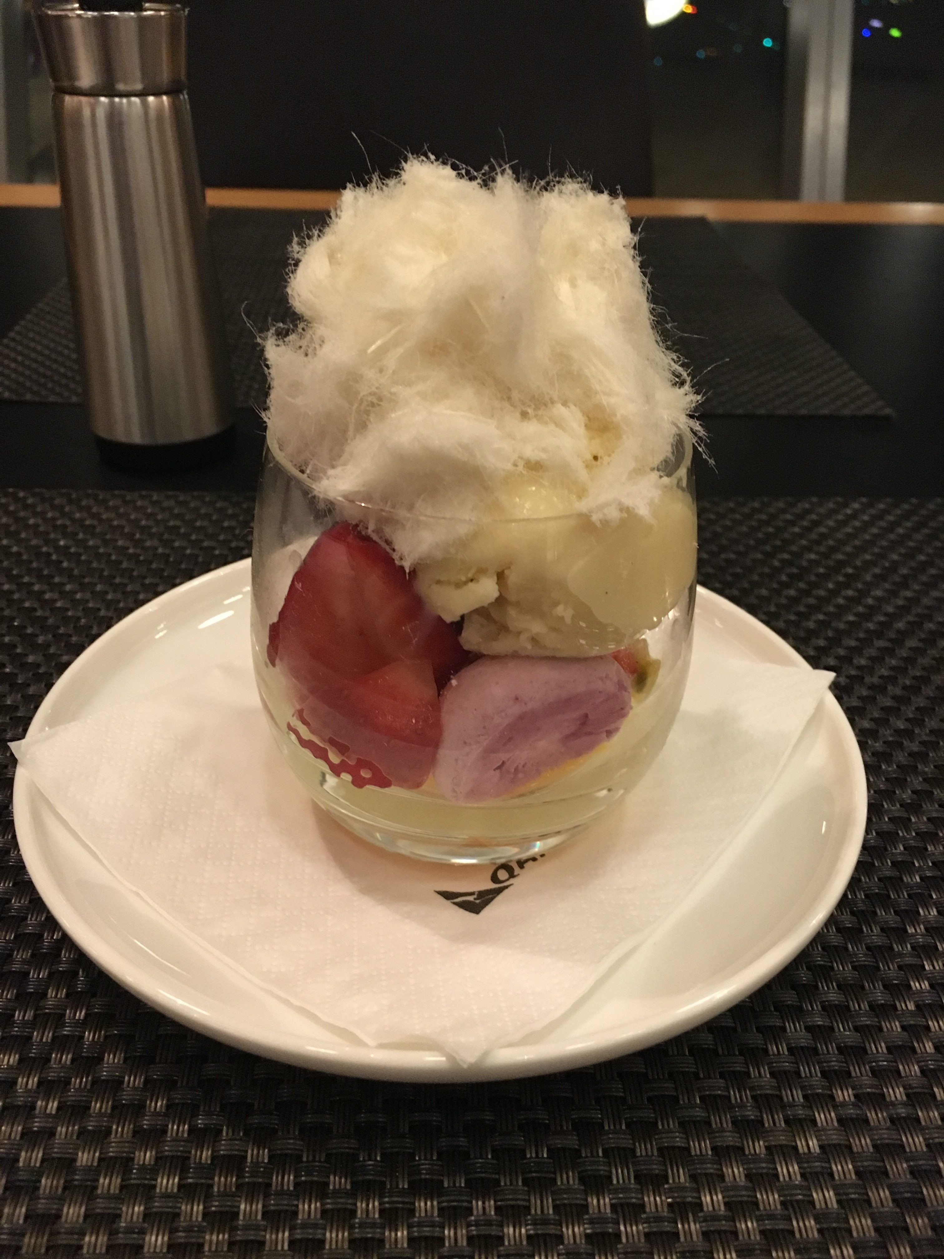a glass with fruit and ice cream on a plate
