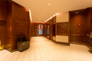 a hallway with wood walls and a sign