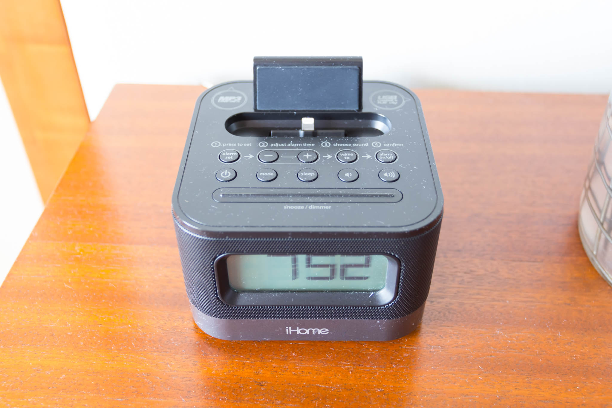 a black alarm clock on a wood surface