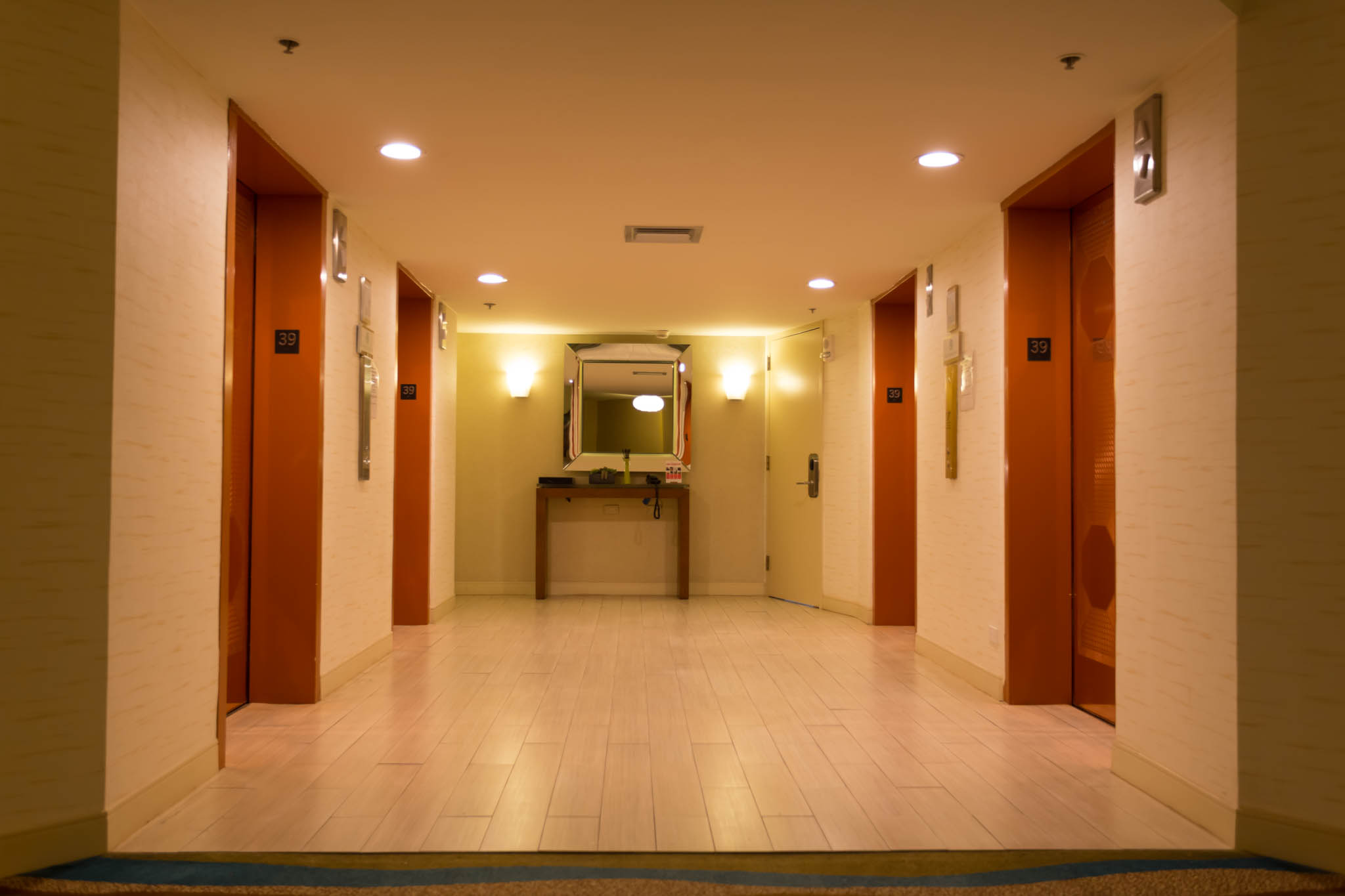 a hallway with two doors and a mirror